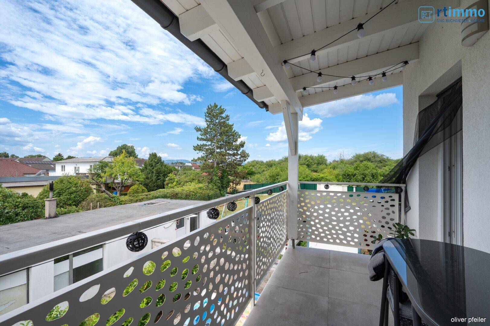 Heller Balkon mit moderner Brüstung, bietet weite Aussicht über die Umgebung.