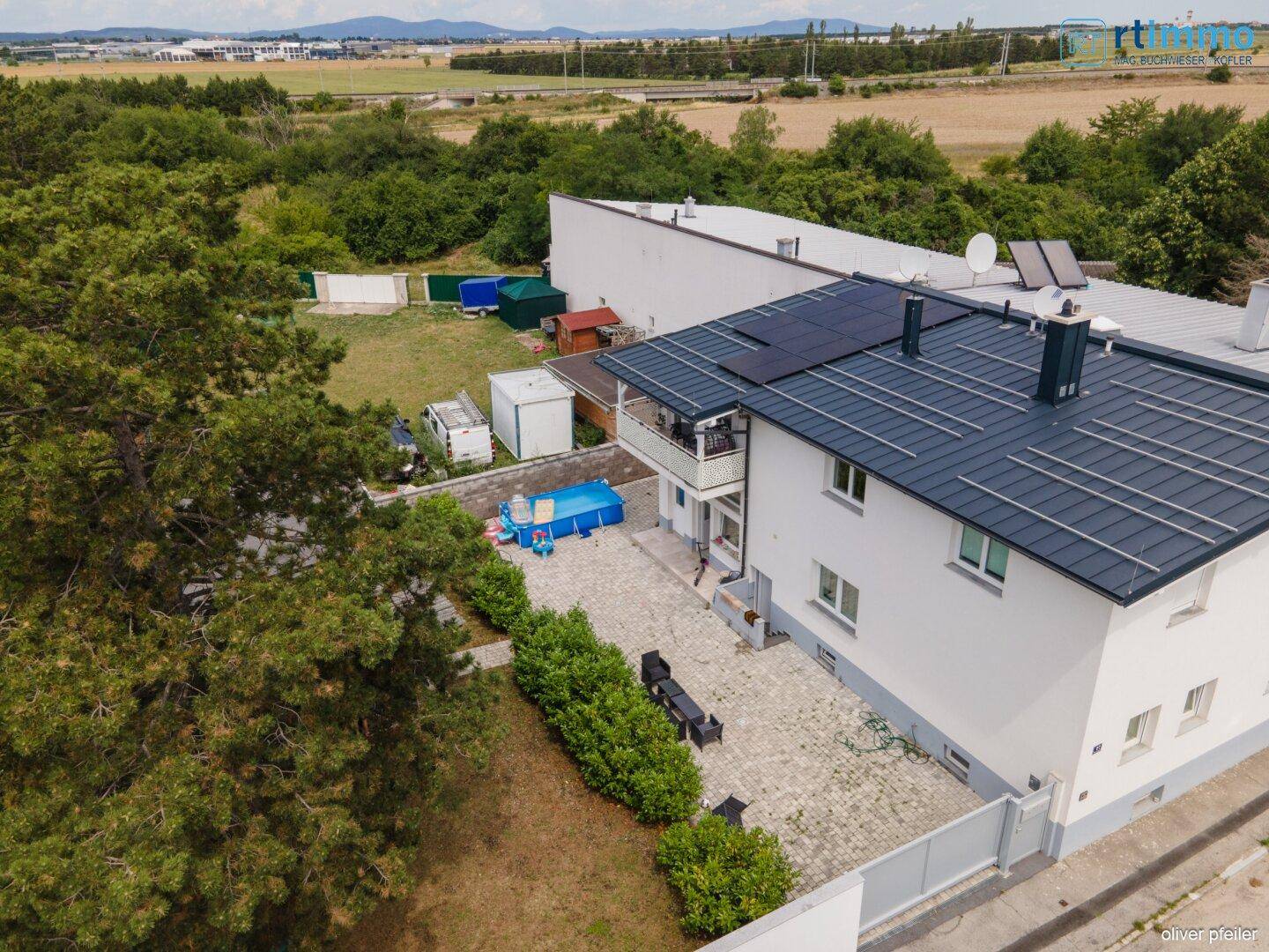 Weitläufige Luftaufnahme des Anwesens mit Haus, Hof, Pool und umgebender grüner Landschaft.