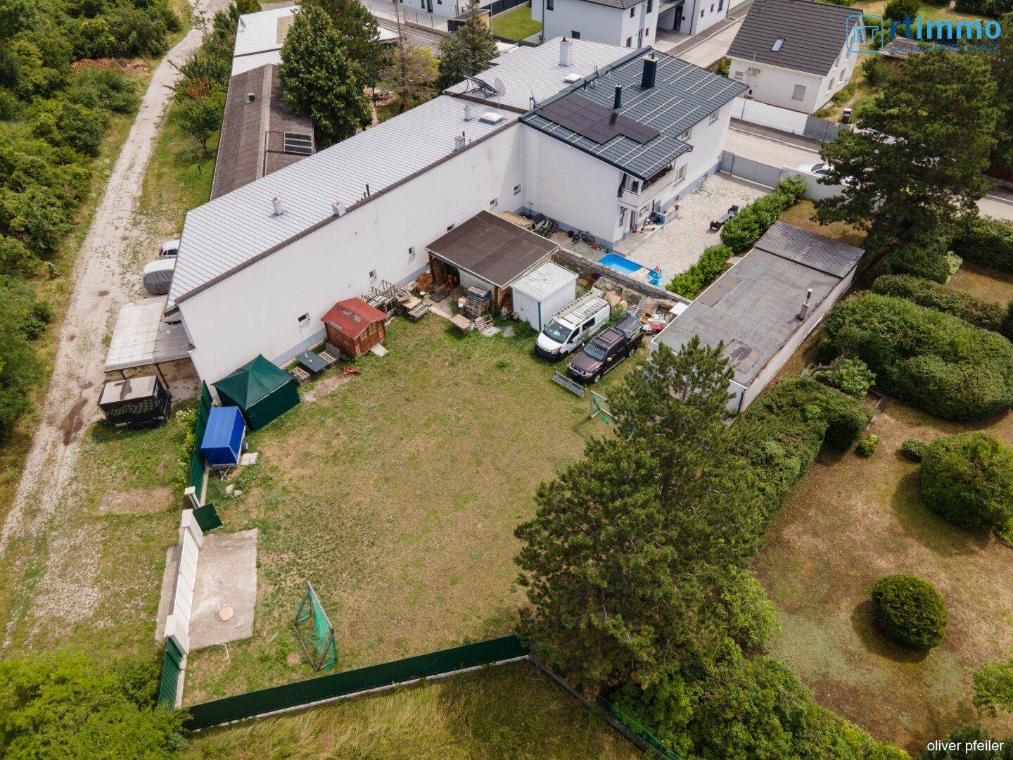 Luftaufnahme des Grundstücks mit großem Gartenbereich, Nebengebäuden und angrenzenden Häusern.