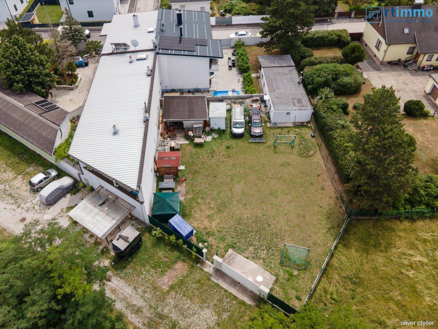 Luftaufnahme des Grundstücks mit großem Gartenbereich, Nebengebäuden und angrenzenden Häusern.