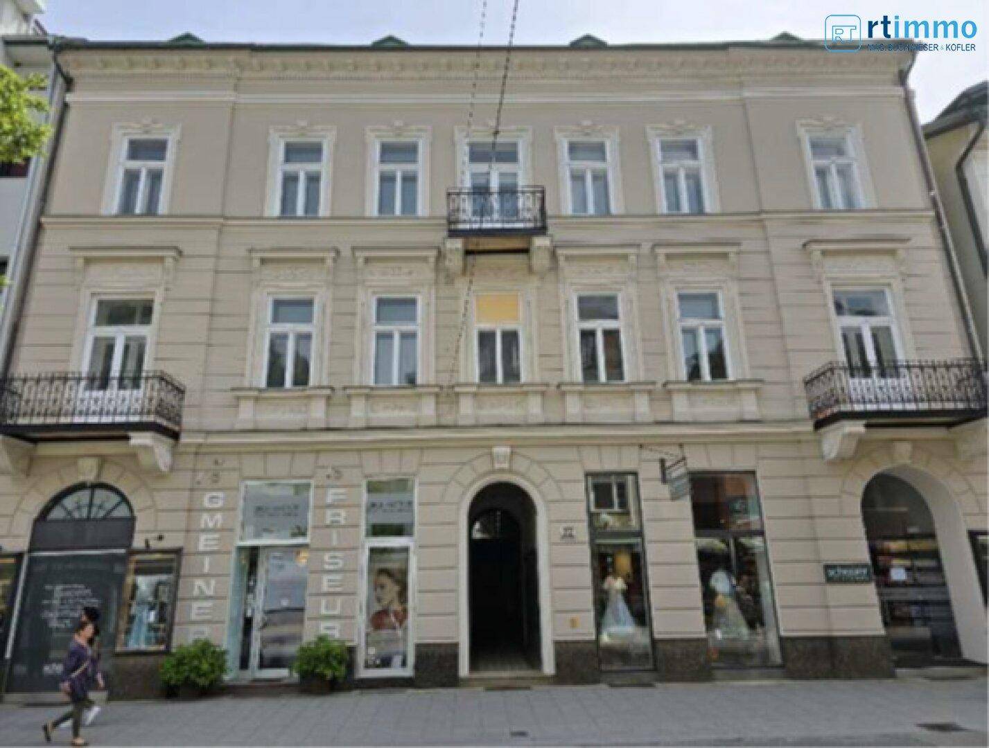Historisches Mehrfamilienhaus mit klassischer Fassade, dekorativen Elementen und Balkonen in städtischer Umgebung.