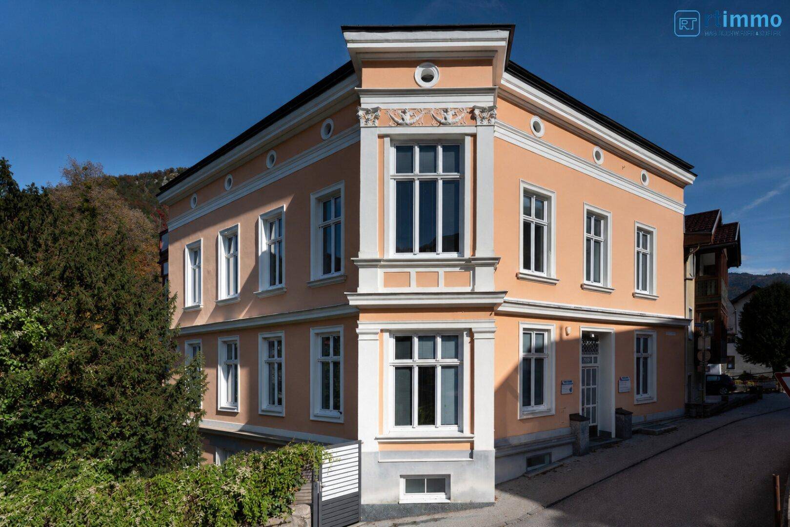 Historisches Eckgebäude mit eleganter Fassade und großen Fenstern.