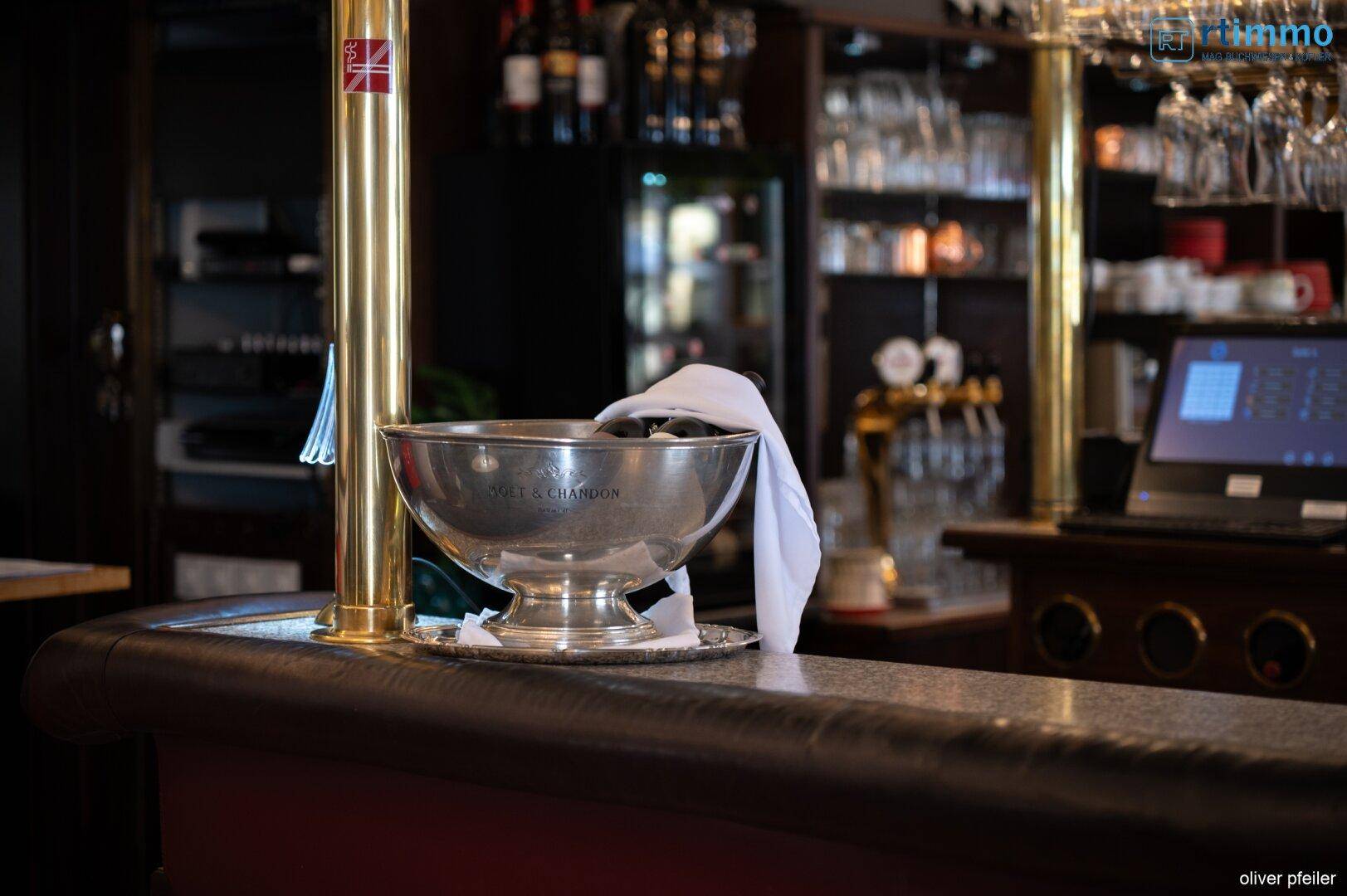 Detailansicht einer Champagnerschale auf der Bartheke, umgeben von goldenen Akzenten.