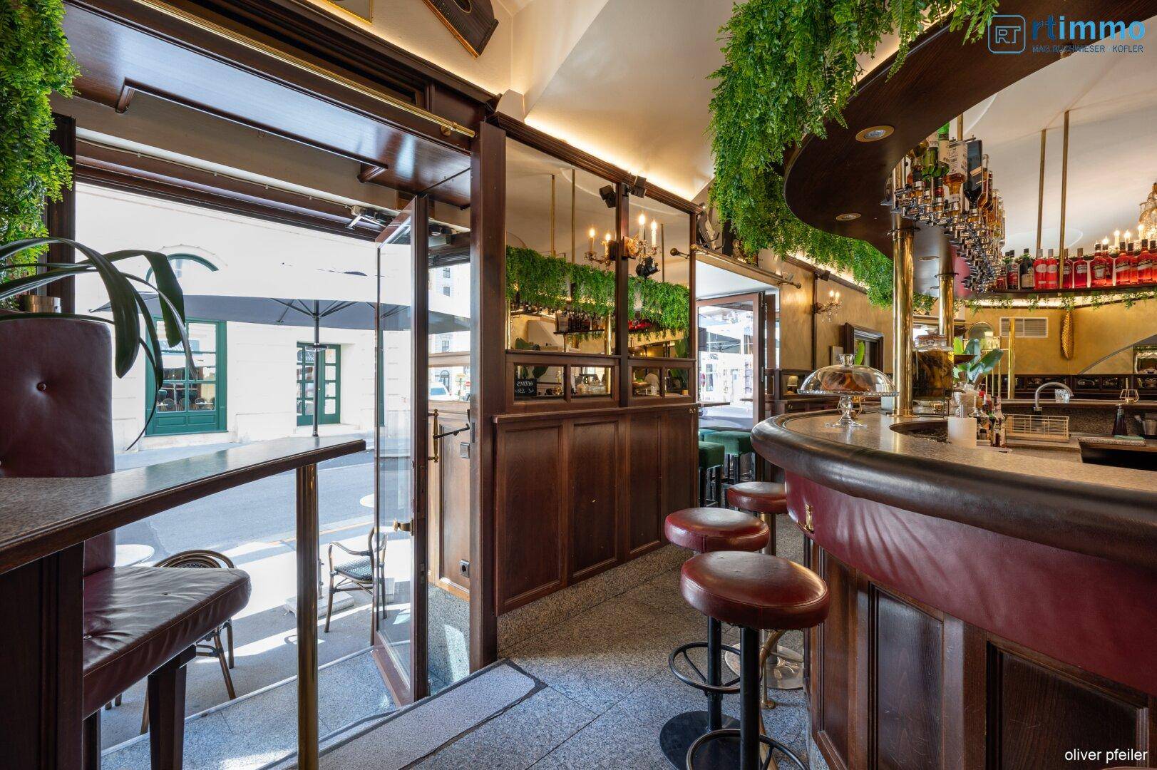 Der Eingangsbereich der Bar mit Blick nach draußen und Barhockern an der Theke.