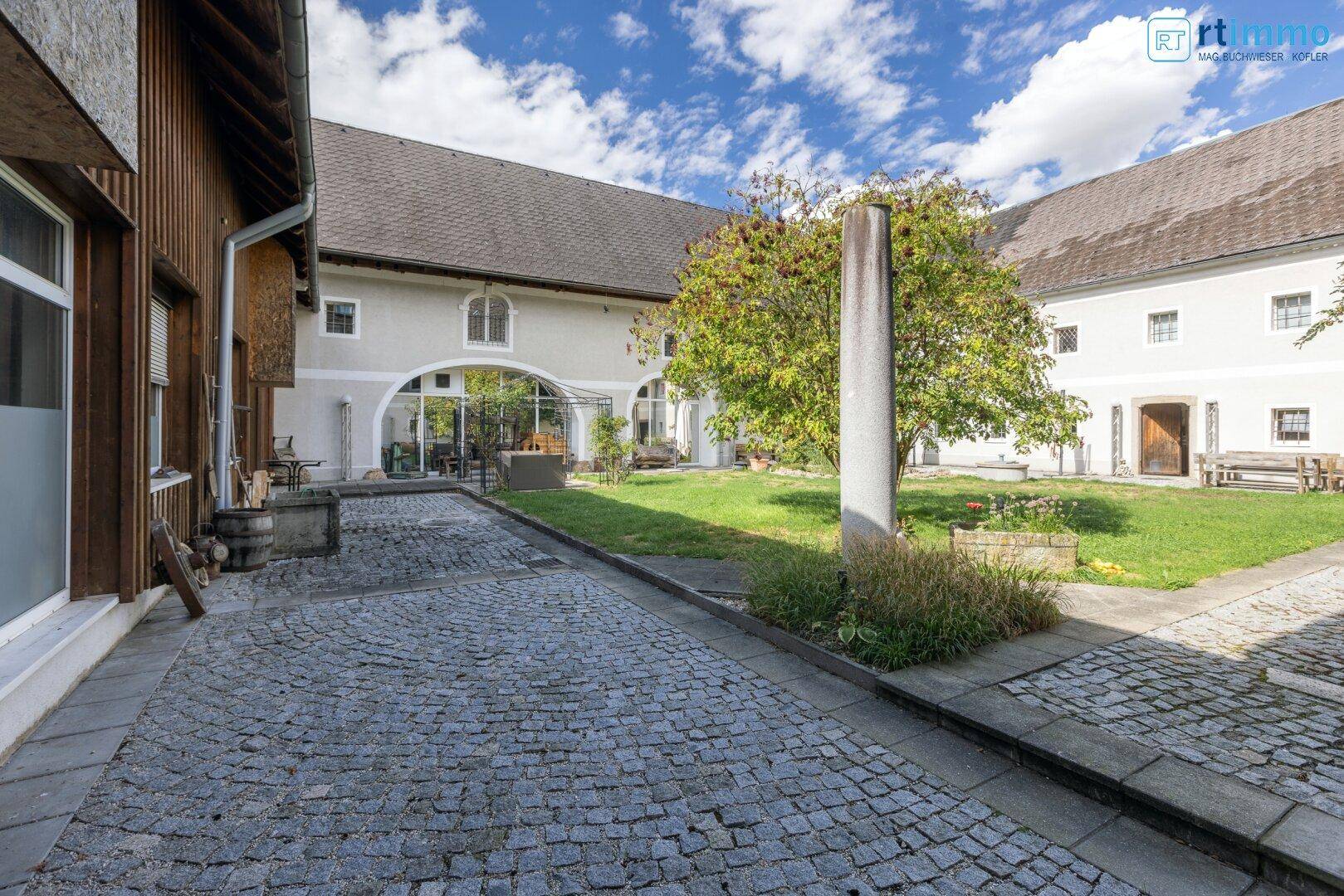Gepflasterter Innenhof mit Kopfsteinpflaster und einem Baum, umgeben von den historischen Gebäuden.