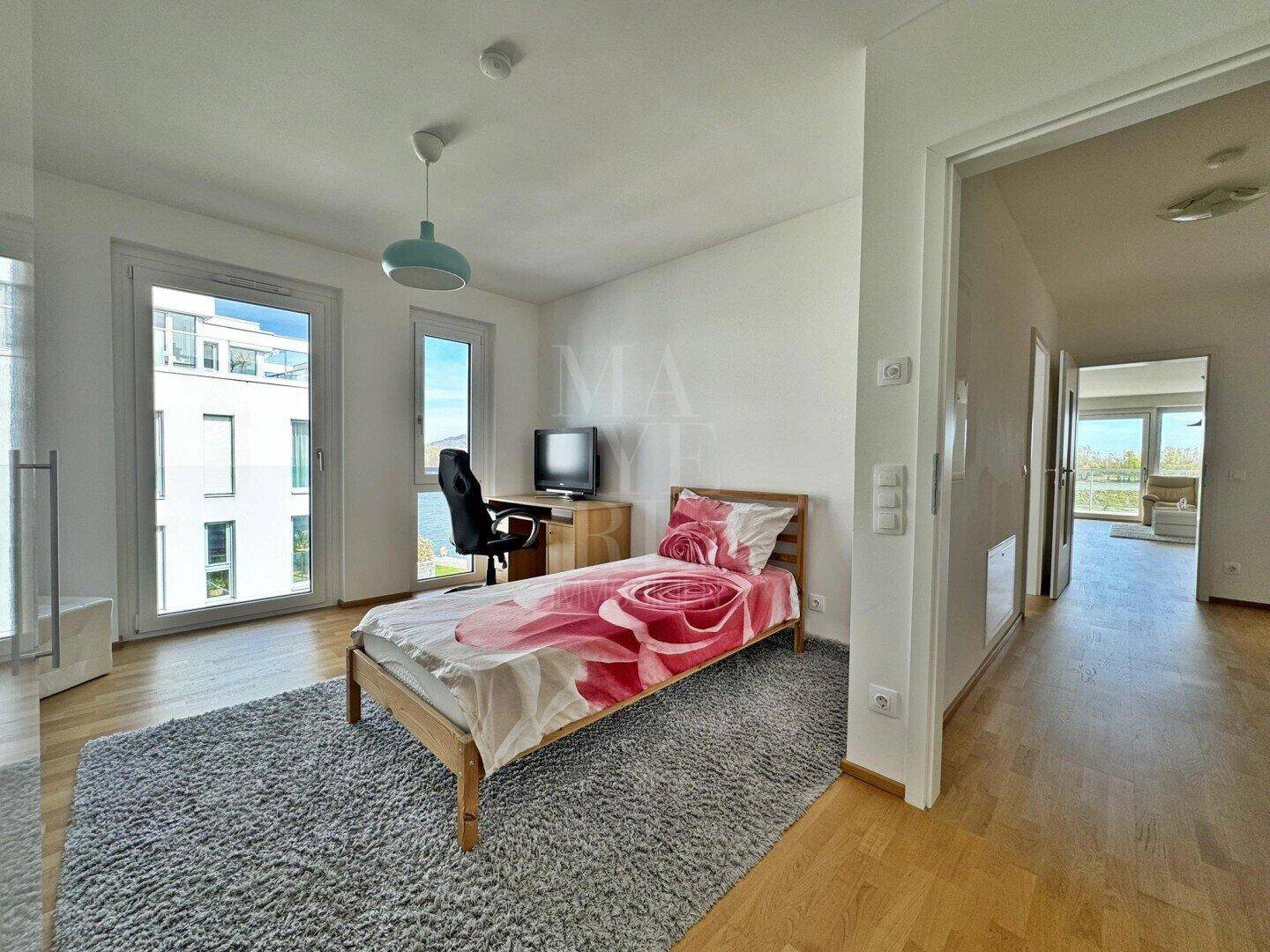 Kinderzimmer oder Gästezimmer mit Holzboden, Schreibtisch und Blick ins Grüne.