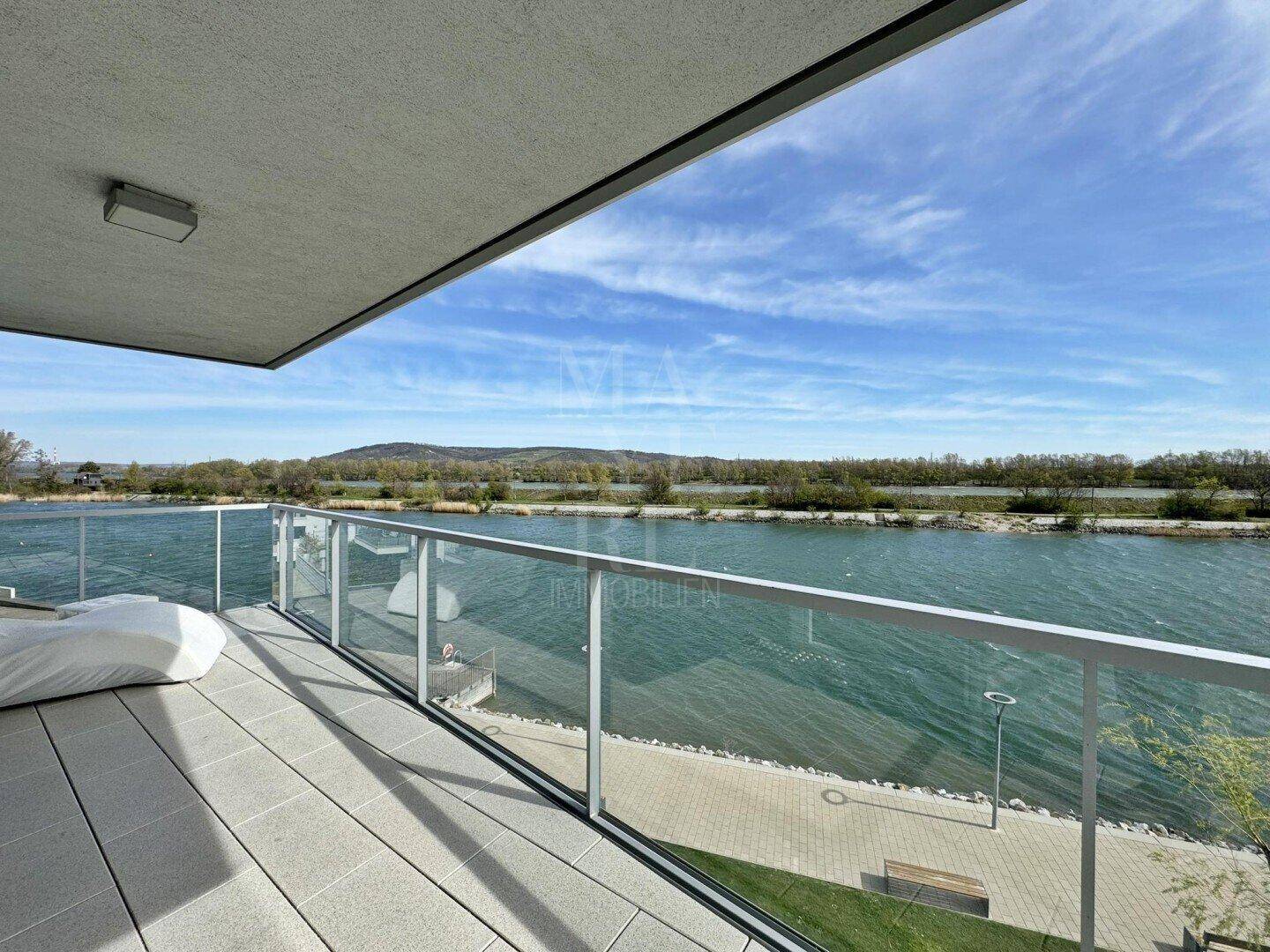 Heller Balkon mit Panoramablick auf das Wasser und die umliegende Landschaft.