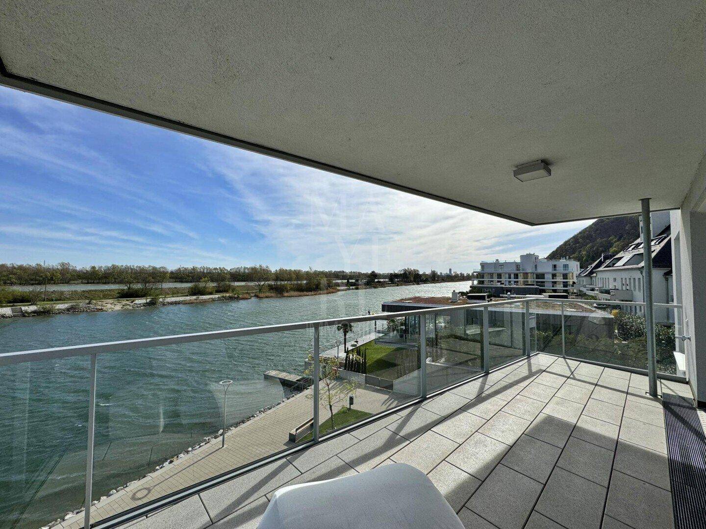 Breiter Balkon mit Seeblick und moderner Glasbrüstung, ideal zum Entspannen im Freien.
