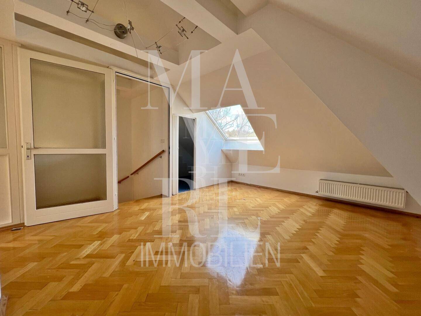 Ausgebauter Dachbodenraum mit Parkettboden, Dachschräge und Dachfenster, ideal als Hobbyraum.