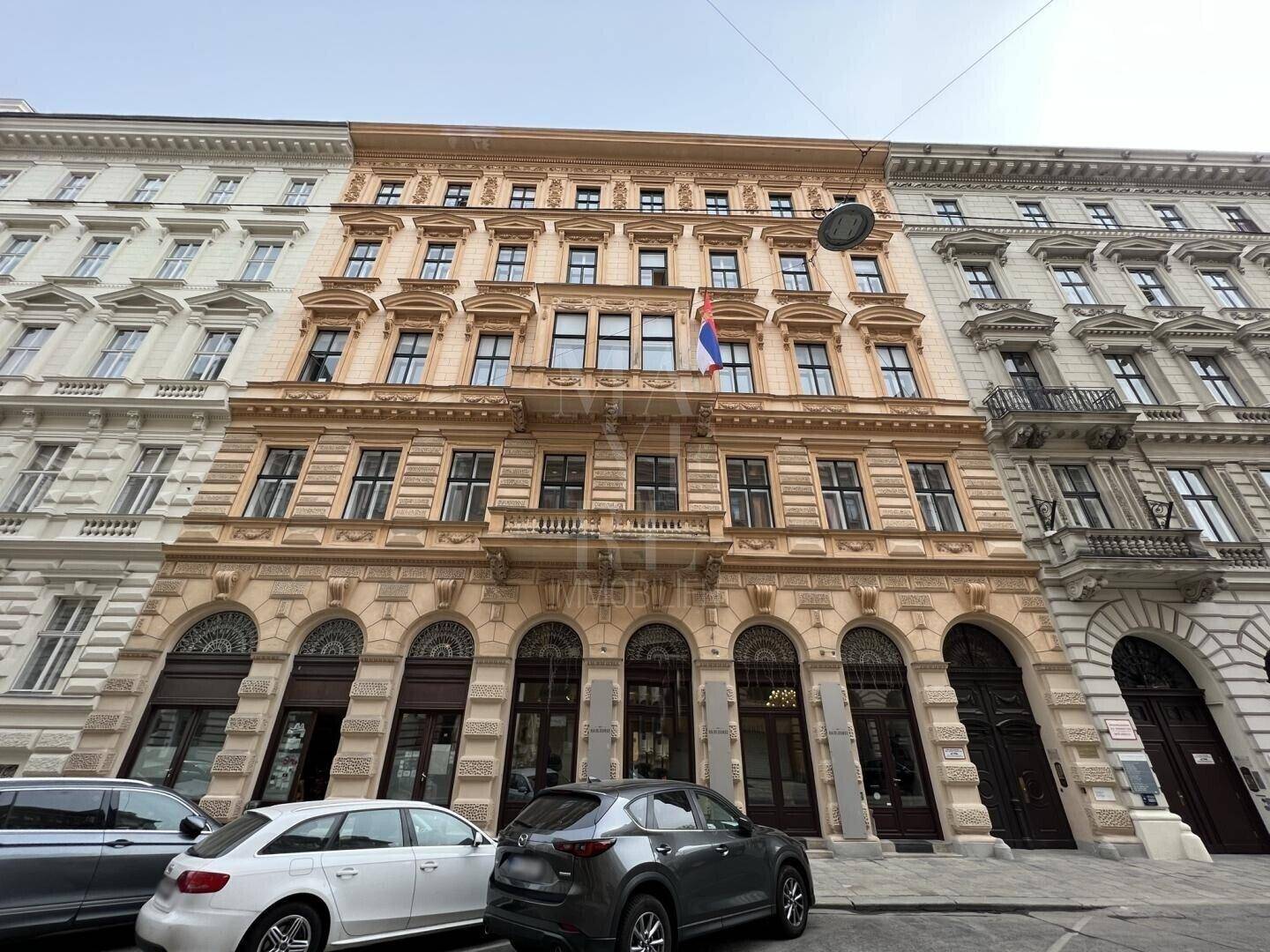 Prächtige historische Fassade eines Altbaus mit vielen Fenstern und dekorativen Elementen.