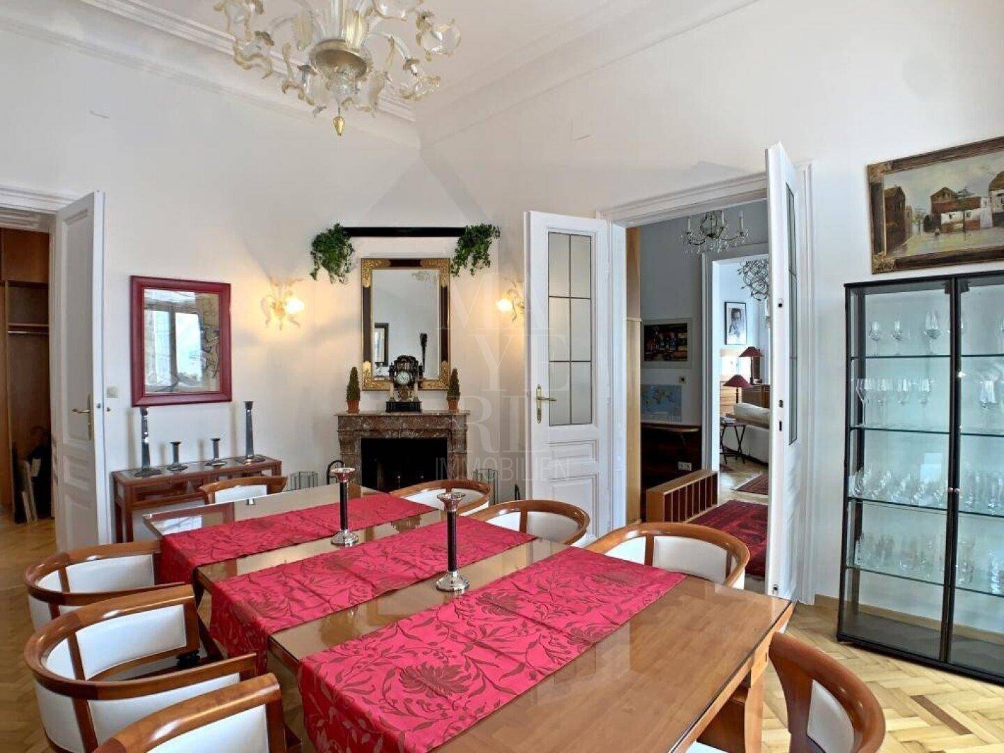Klassisches Esszimmer mit Kamin, Parkettboden und einem großen Esstisch für gesellige Runden.