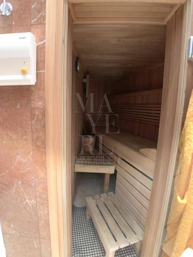 Private Sauna mit Holzbänken und warmem Licht, ideal zur Entspannung.