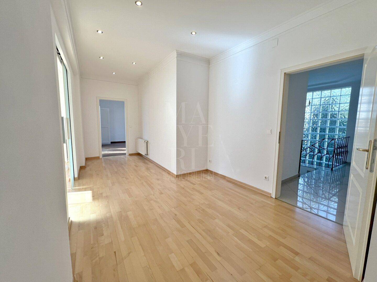 Heller Flur mit Parkettboden und einer dekorativen Glasbausteinwand, die Licht spendet.