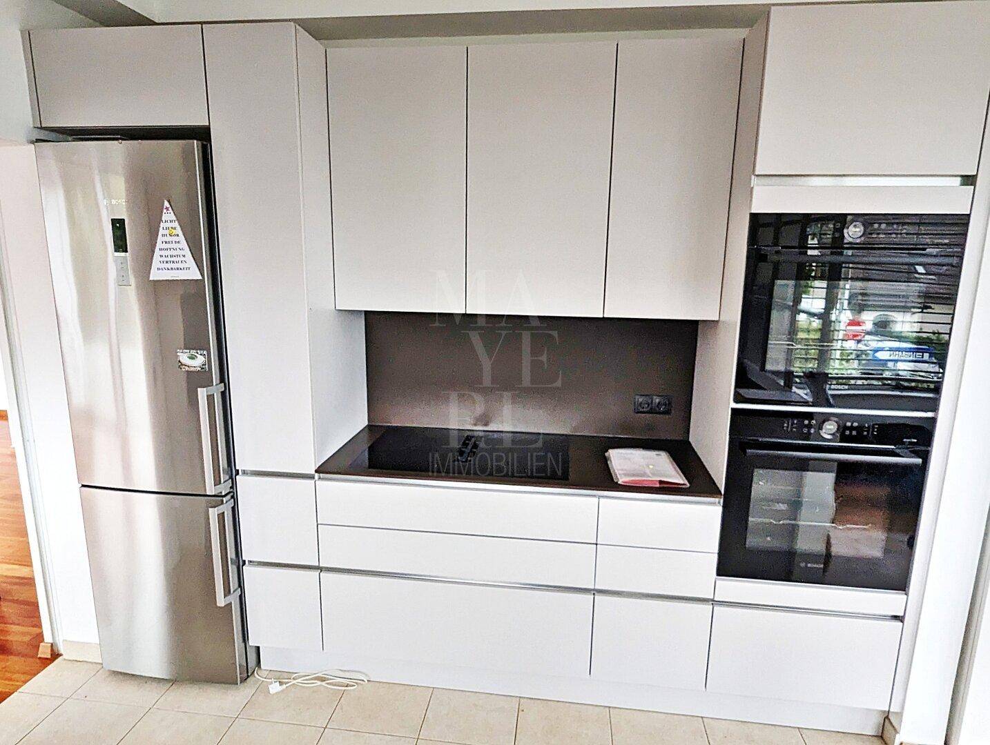 Hochwertige Einbauküche mit modernen Geräten, Induktionskochfeld und integriertem Backofen.