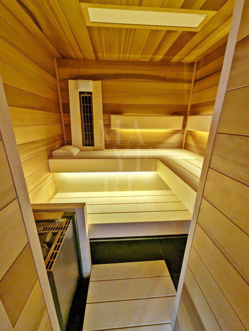 Exklusive Holzsauna mit indirekter Beleuchtung und bequemen Sitzbänken für Entspannung.