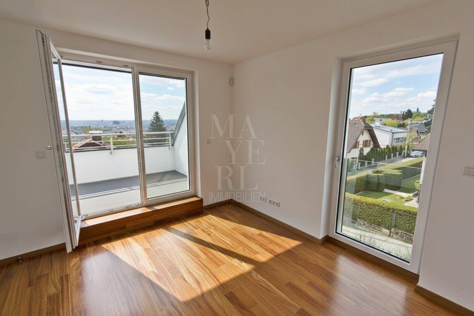 Helles Zimmer mit Zugang zu einem Balkon und weitem Blick über die Stadt und die Umgebung.