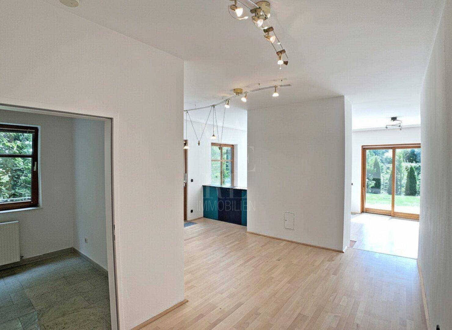 Heller Flurbereich mit Parkettboden, der zu verschiedenen Räumen und einem Balkon führt.
