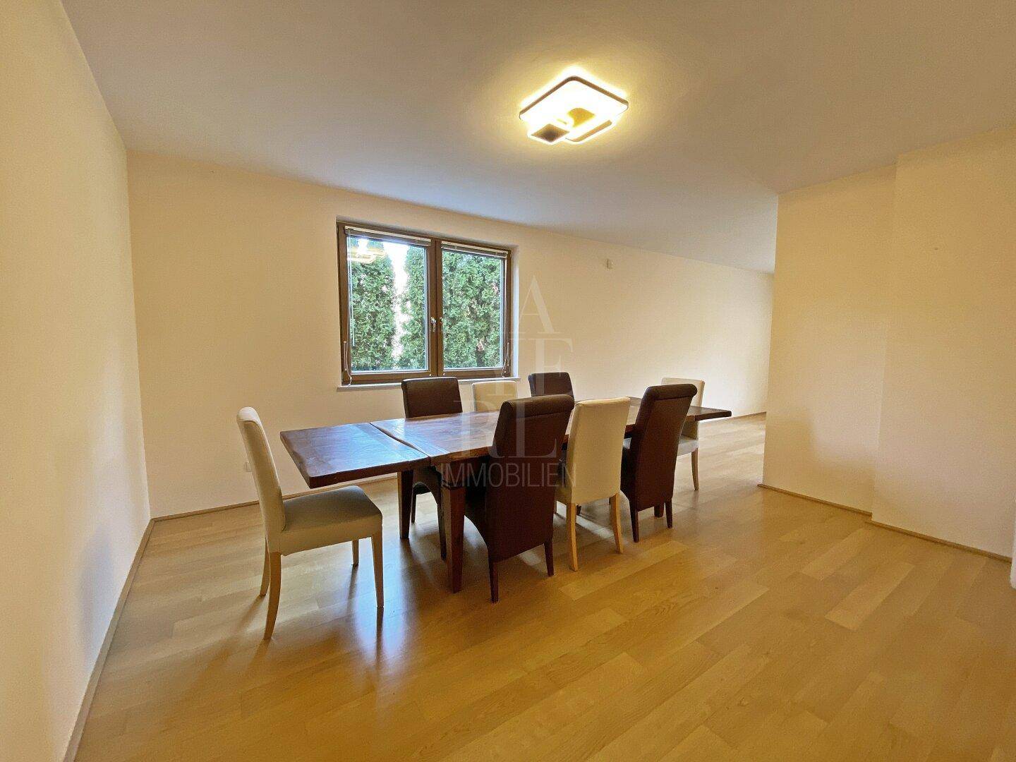 Geräumiges Esszimmer mit großem Holztisch und Parkettboden, ideal für Familienessen.