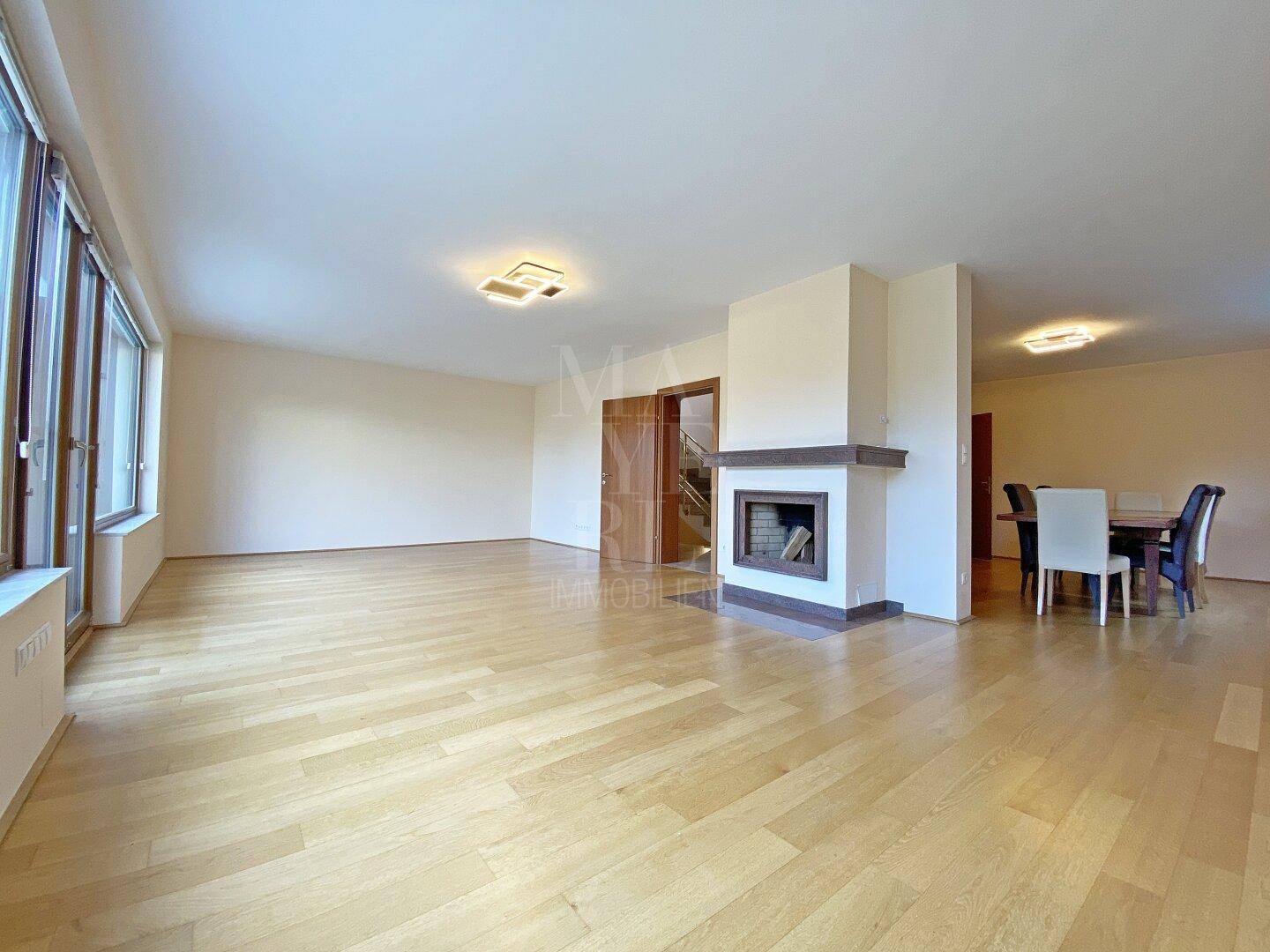 Geräumiger Wohn- und Essbereich mit Kamin und hellem Parkettboden, ideal für gesellige Stunden.