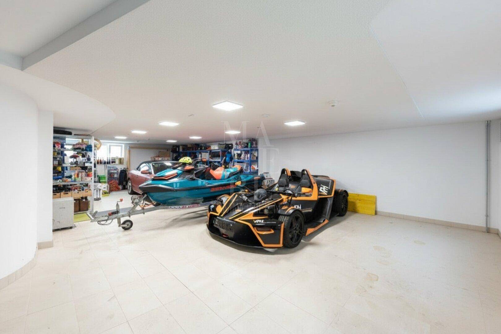 Große Tiefgarage mit viel Platz für Fahrzeuge und Regalen zur Aufbewahrung von Ausrüstung.