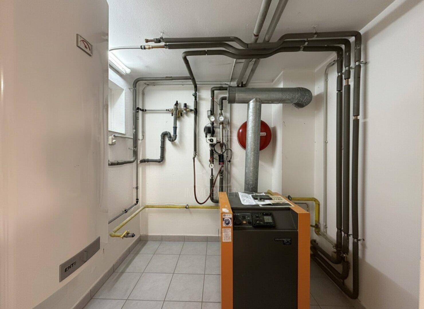 Technikraum mit Heizungsanlage und sichtbaren Rohrleitungen, gut zugänglich.