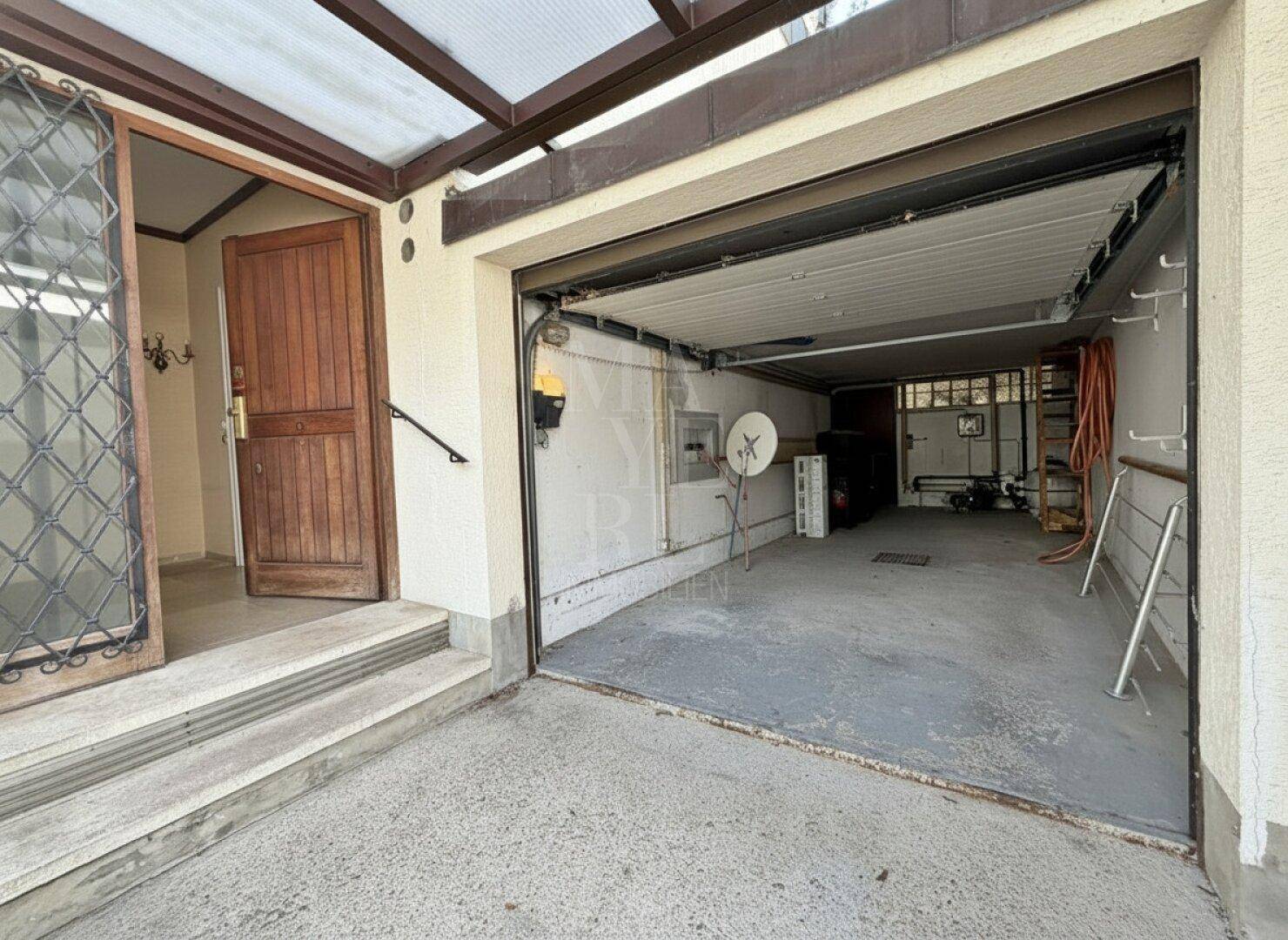 Geräumige Garage mit offenem Tor und direktem Zugang zum Haus.