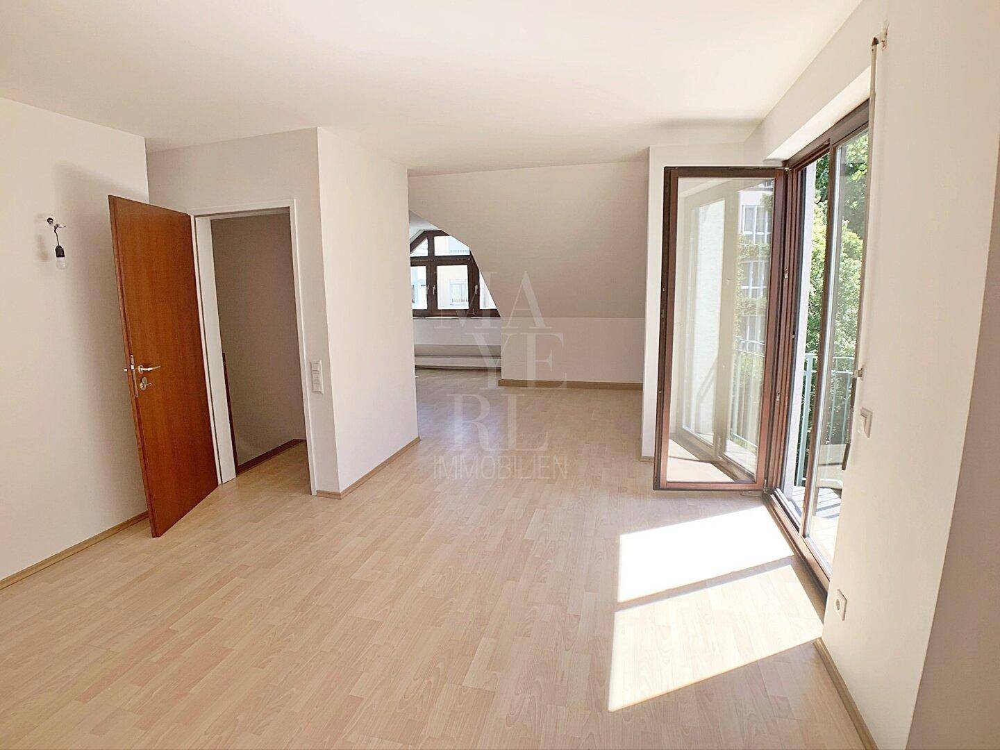 Dachgeschossraum mit Parkettboden und Balkonzugang, bietet flexible Nutzungsmöglichkeiten.
