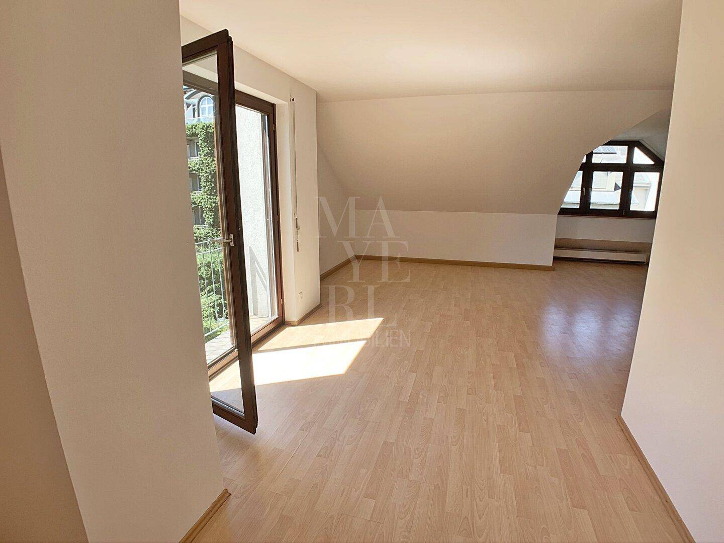 Helles Dachgeschosszimmer mit Parkettboden und Balkonzugang, ideal als zusätzlicher Wohnraum.