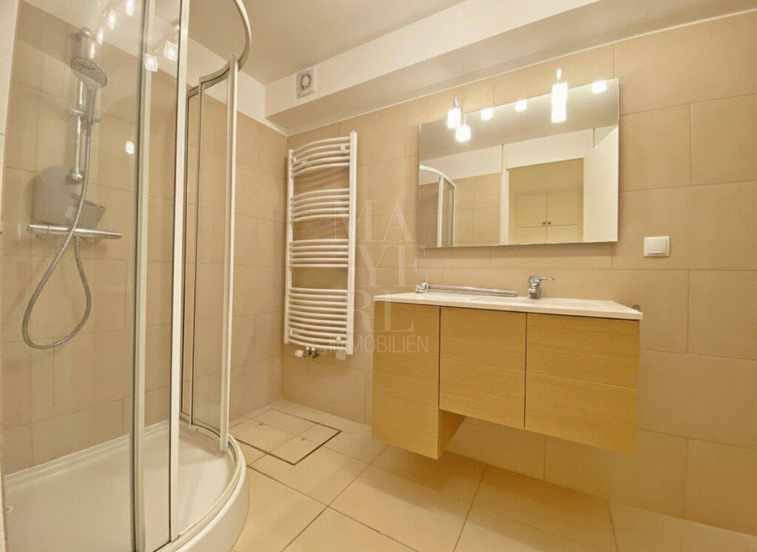 Modernes Badezimmer mit Eckdusche, Einzelwaschbecken und beheiztem Handtuchhalter.
