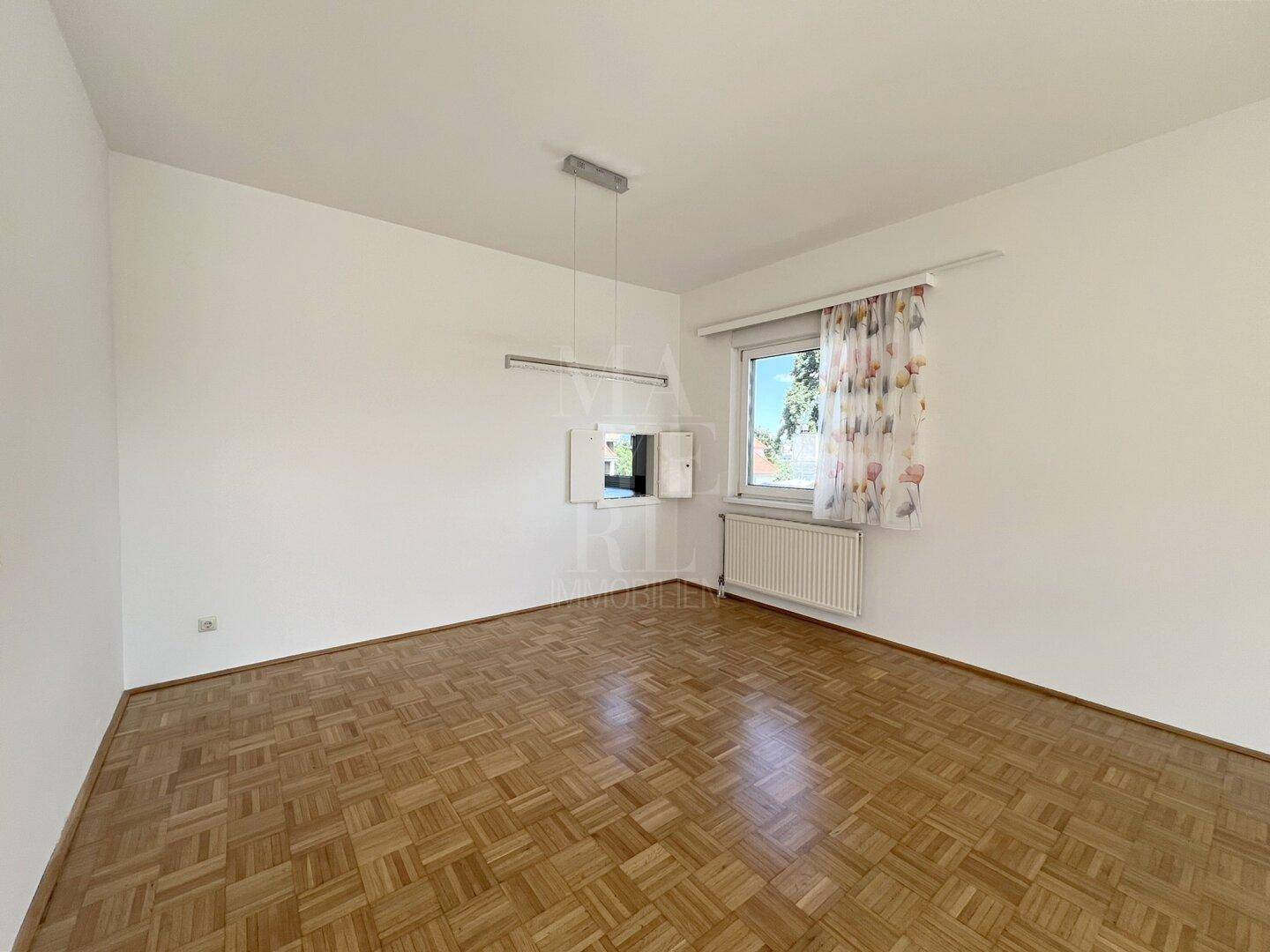 Heller Raum mit Parkettboden und Fenster, ideal als Schlaf- oder Arbeitszimmer nutzbar.