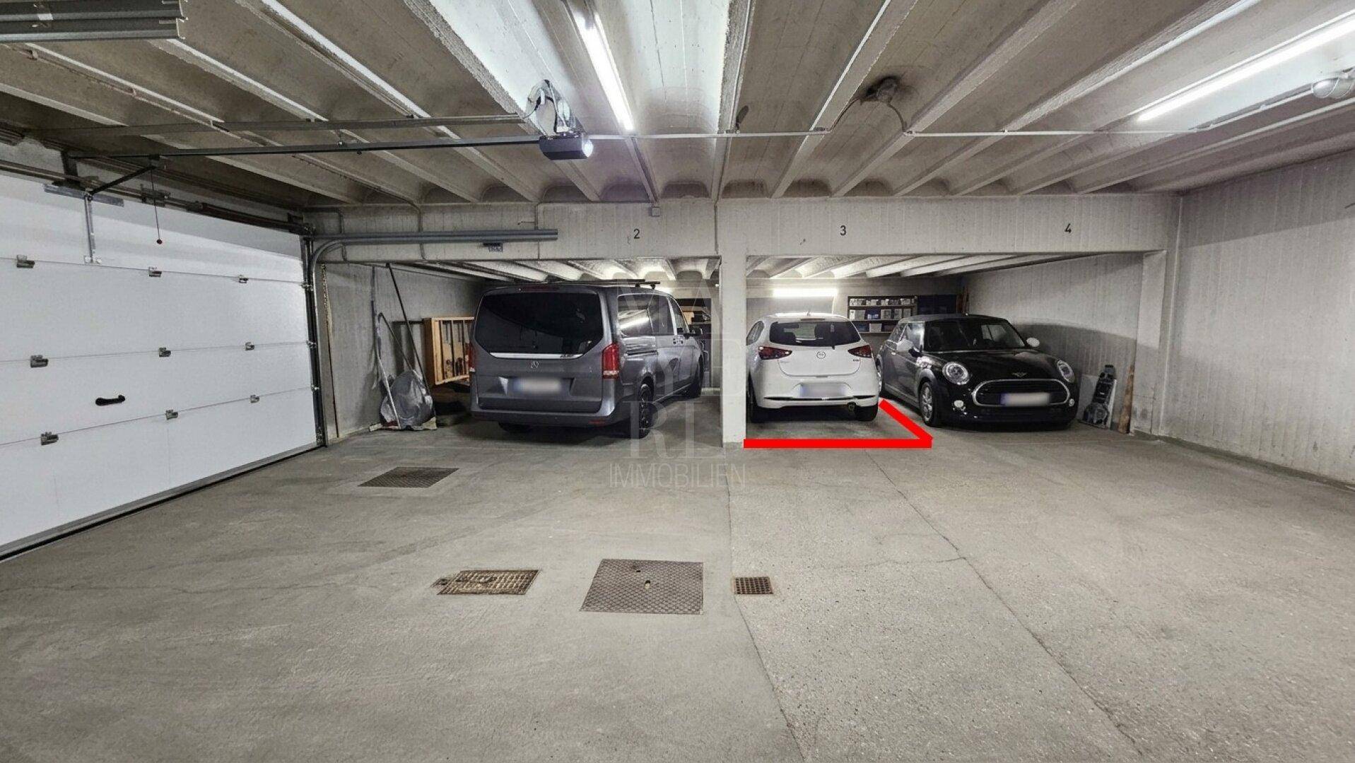 Tiefgarage mit mehreren Stellplätzen und Betonboden.
