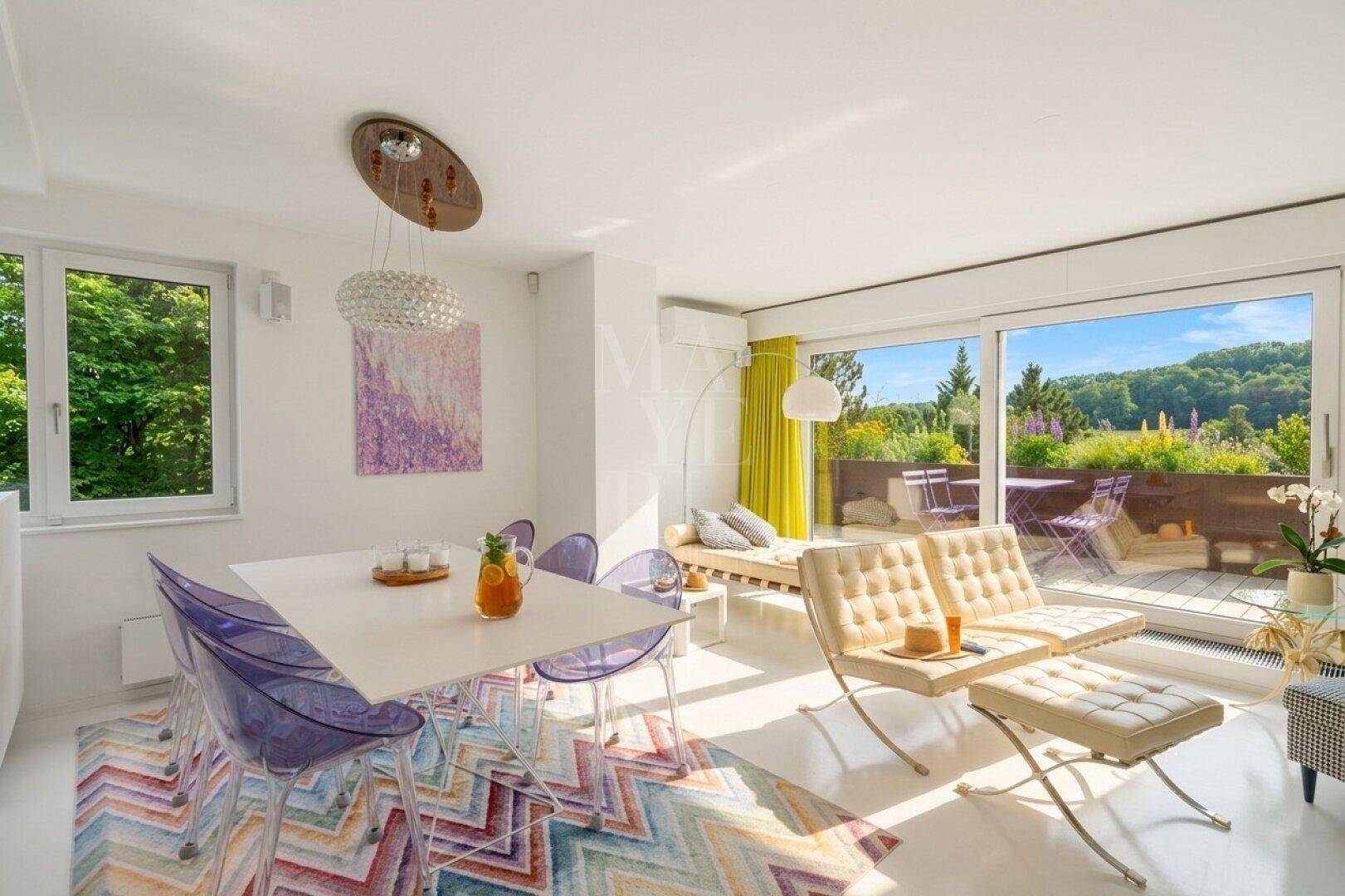 Moderner Wohn- und Essbereich mit farbenfrohem Teppich, Designermöbeln und Zugang zur Dachterrasse.