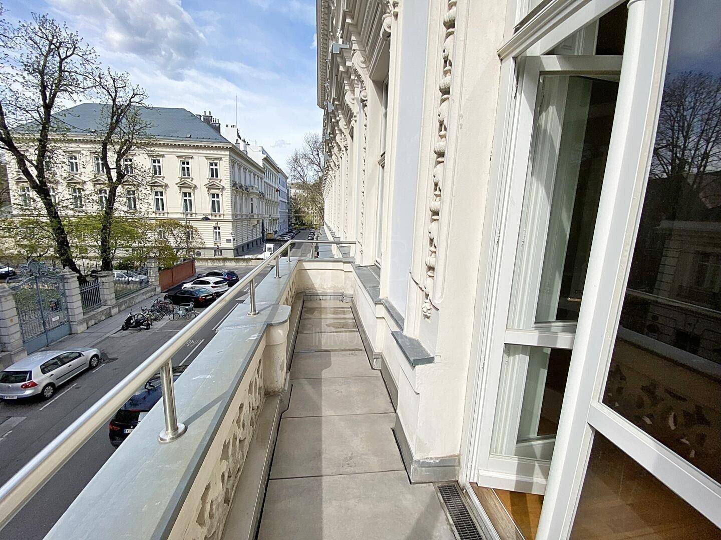 Schmaler Balkon mit Blick auf die historische Architektur und die belebte Stadtstraße.