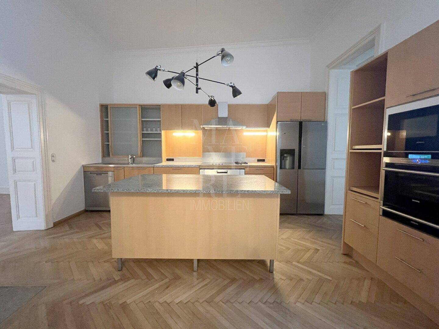 Gut ausgestattete Küche mit Holzfronten, Kücheninsel und modernen Einbaugeräten für kulinarische Erlebnisse.