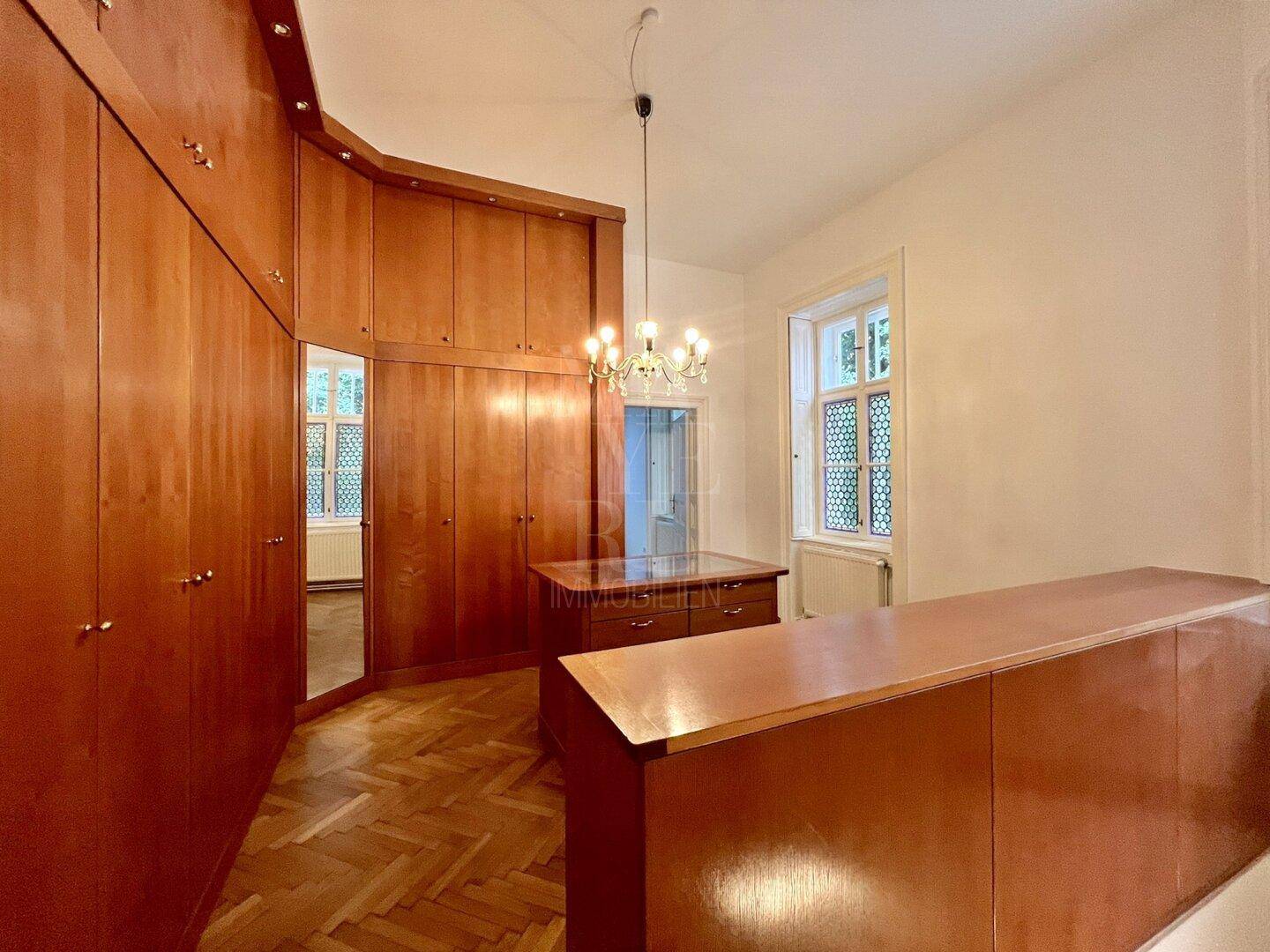 Schlafzimmer mit maßgefertigten Holzschränken und viel Stauraum, ideal als Ankleidezimmer gestaltet.