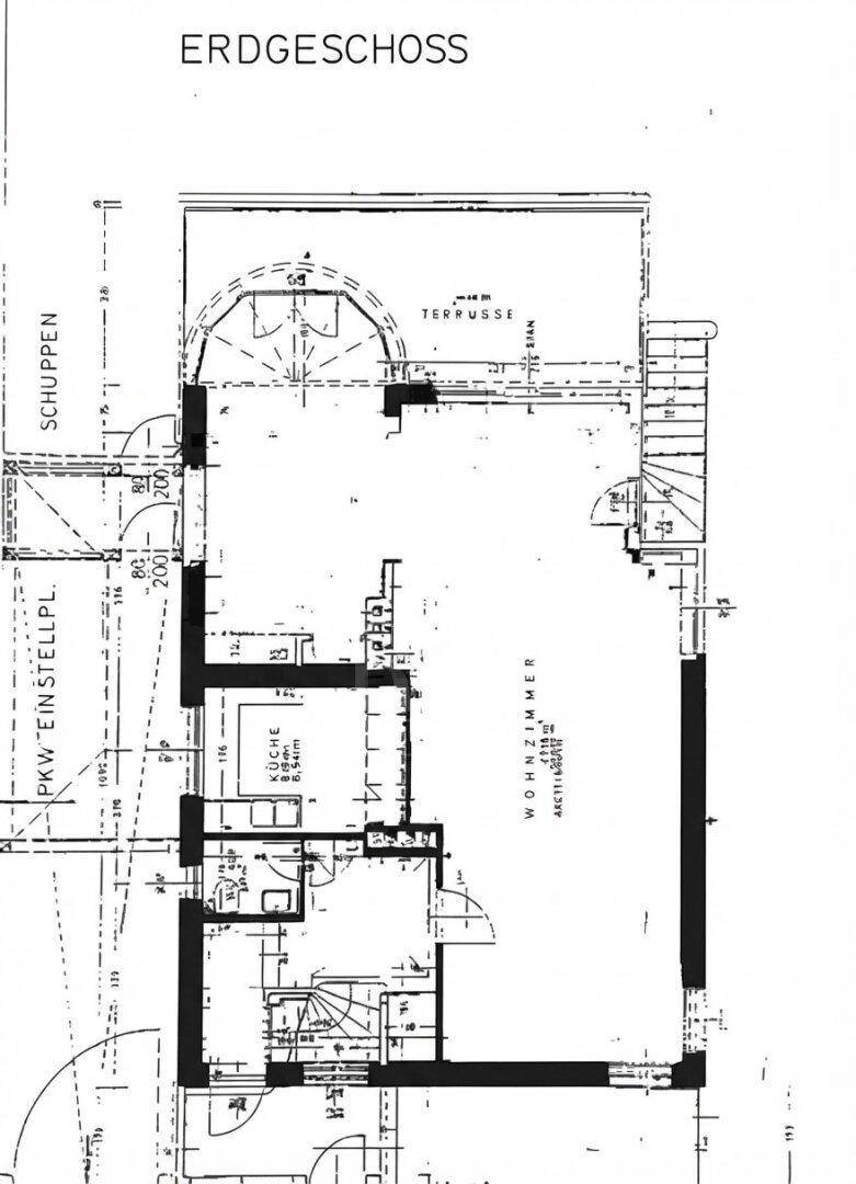 Grundriss des Erdgeschosses mit Wohnzimmer, Küche, Terrasse und PKW-Stellplatz.