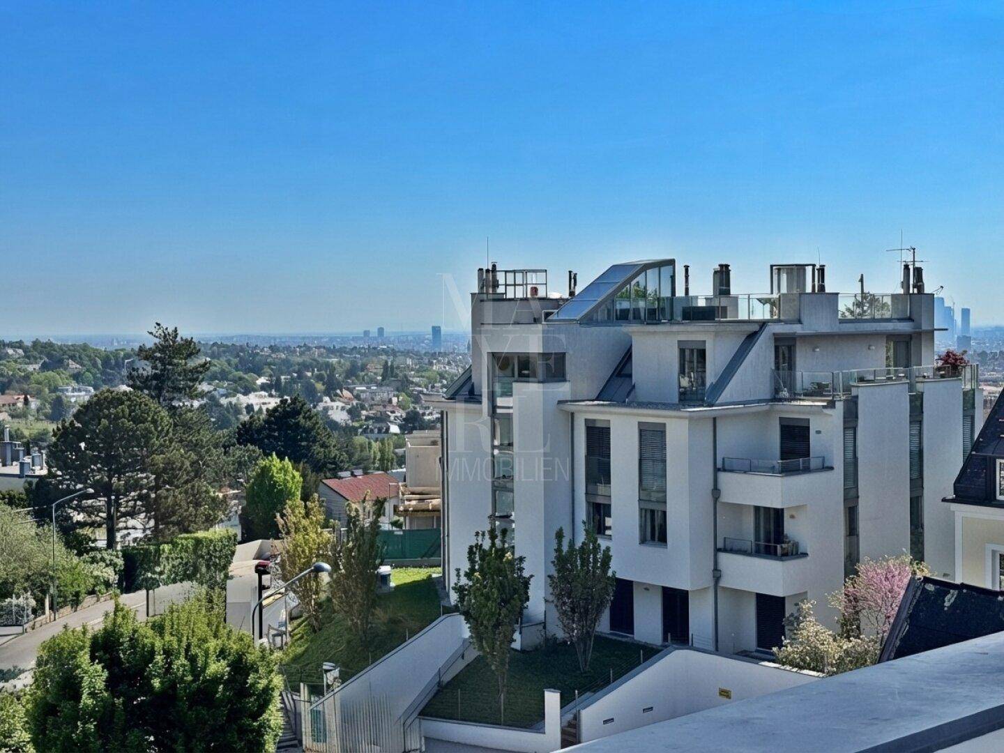 Moderne Architektur des Gebäudes mit mehreren Balkonen und weitem Stadtblick.