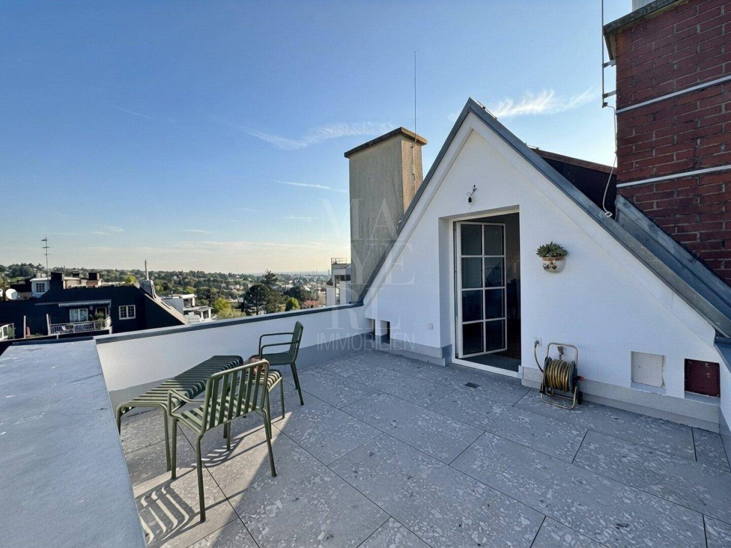 Dachterrasse mit weitem Blick über die Stadt und einfachem Mobiliar.