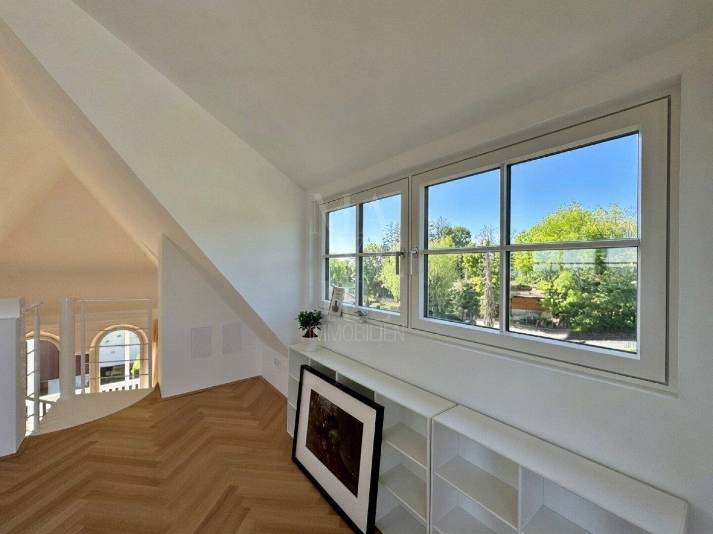 Heller Bereich mit Schrägdach, Fenster und Blick ins Grüne, ideal als Leseecke.