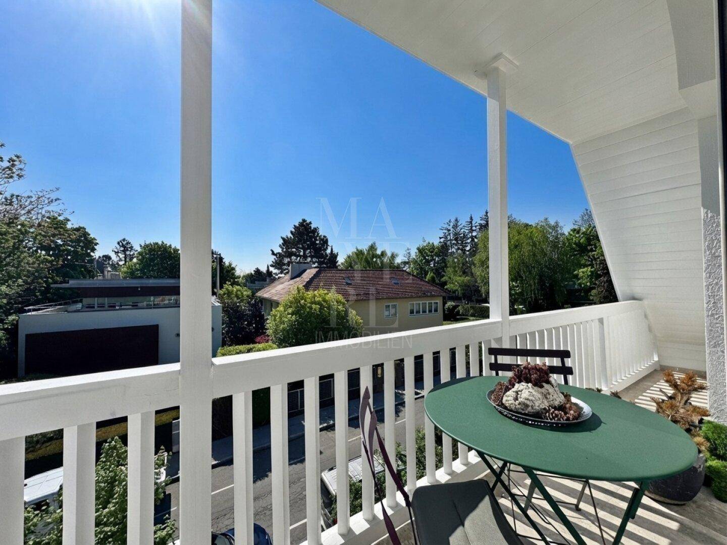 Sonniger Balkon mit Sitzgelegenheiten und Blick auf die umliegende Wohngegend.