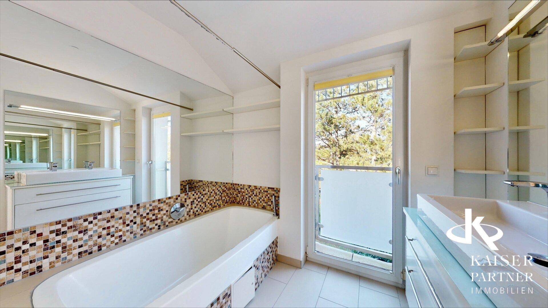 Modernes Badezimmer mit Badewanne, Mosaikfliesen, Doppelwaschbecken und Fenster mit Balkonzugang.
