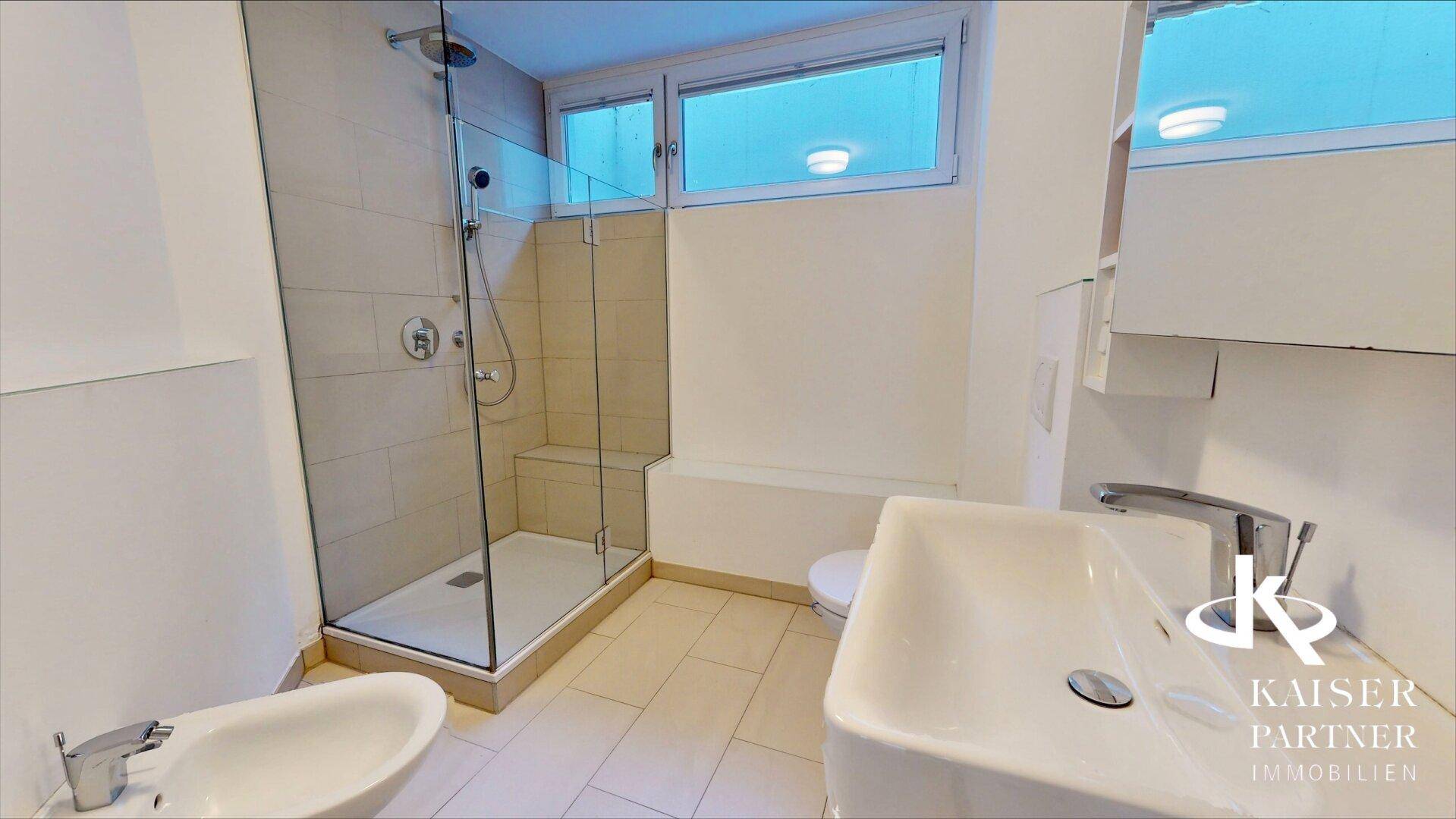Modernes Badezimmer mit ebenerdiger Dusche, Bidet, Einzelwaschbecken und Fenster für Tageslicht.