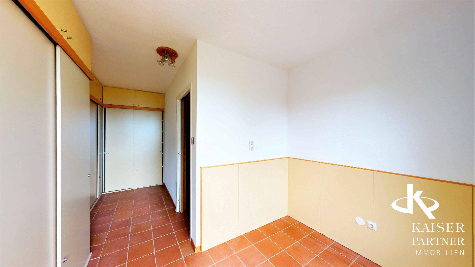 Eingangsbereich oder Zimmer mit Terrakotta-Fliesenboden und praktischen Einbauschränken.
