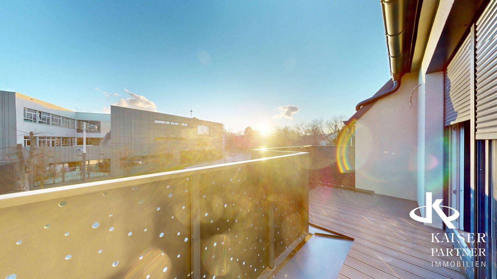 Helle Terrasse mit modernem Geländer und weitem Blick unter strahlendem Sonnenschein.