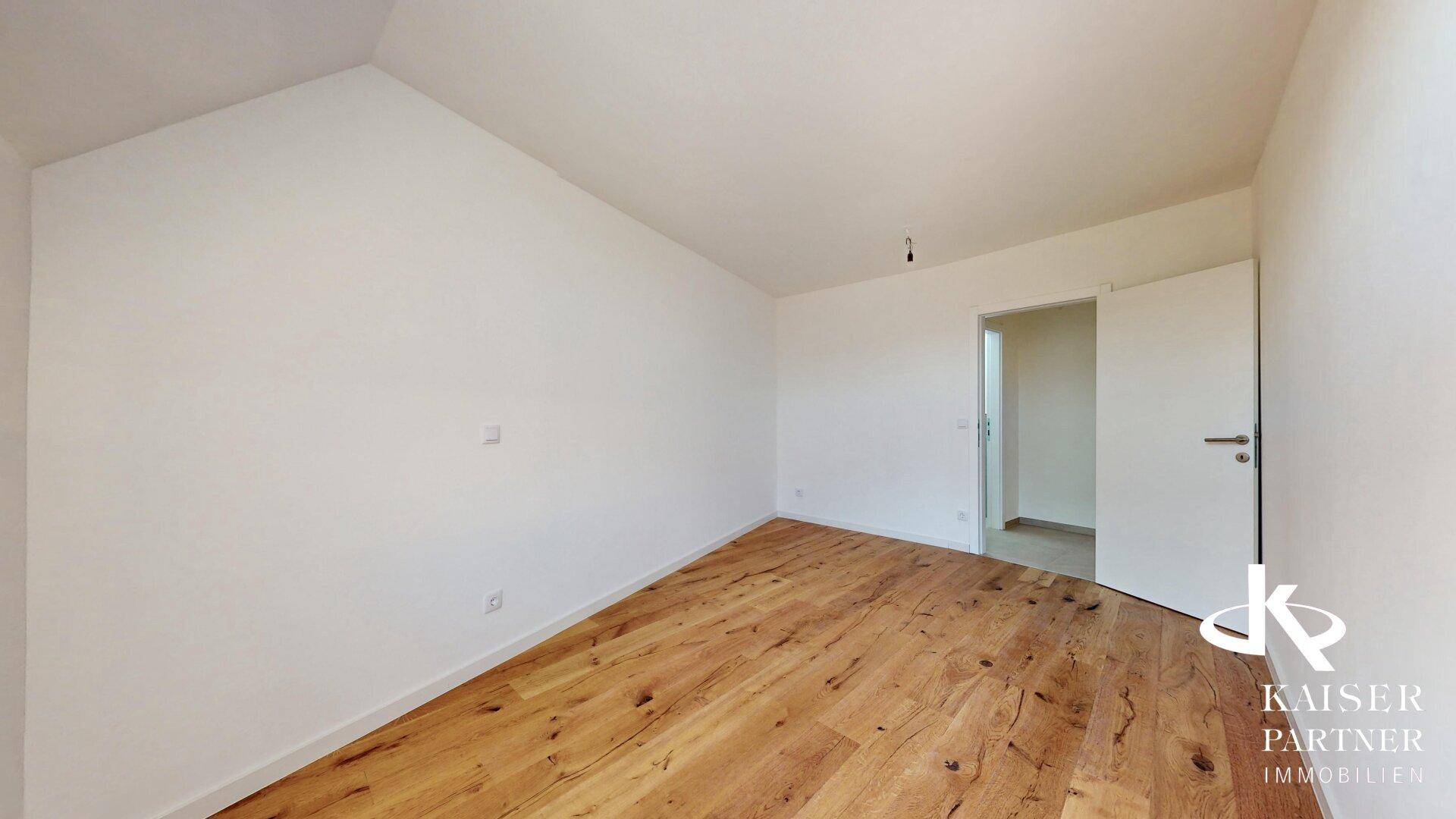 Geräumiges Schlafzimmer im Dachgeschoss mit Holzboden und viel Potenzial zur individuellen Gestaltung.