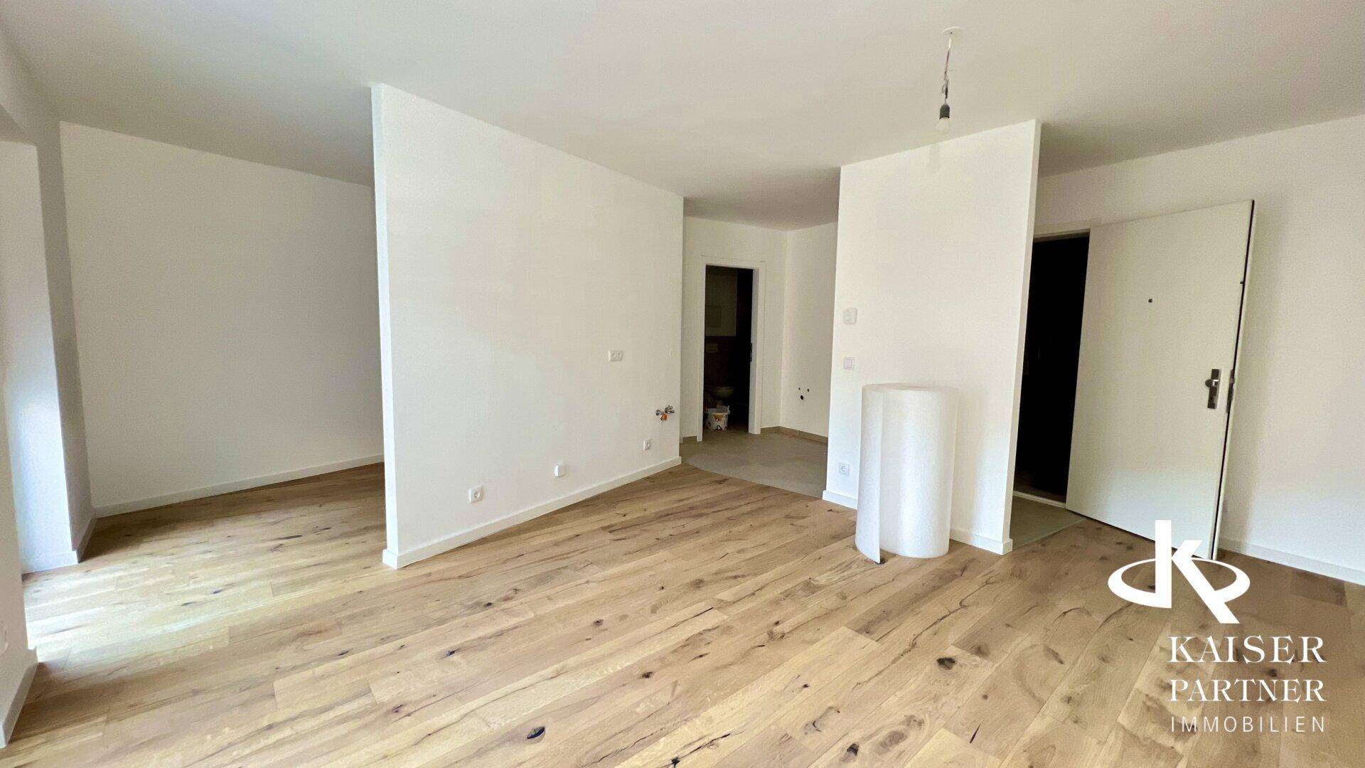 Geräumiger, heller Wohnbereich mit Holzboden und offenem Grundriss, ideal für individuelle Gestaltung.