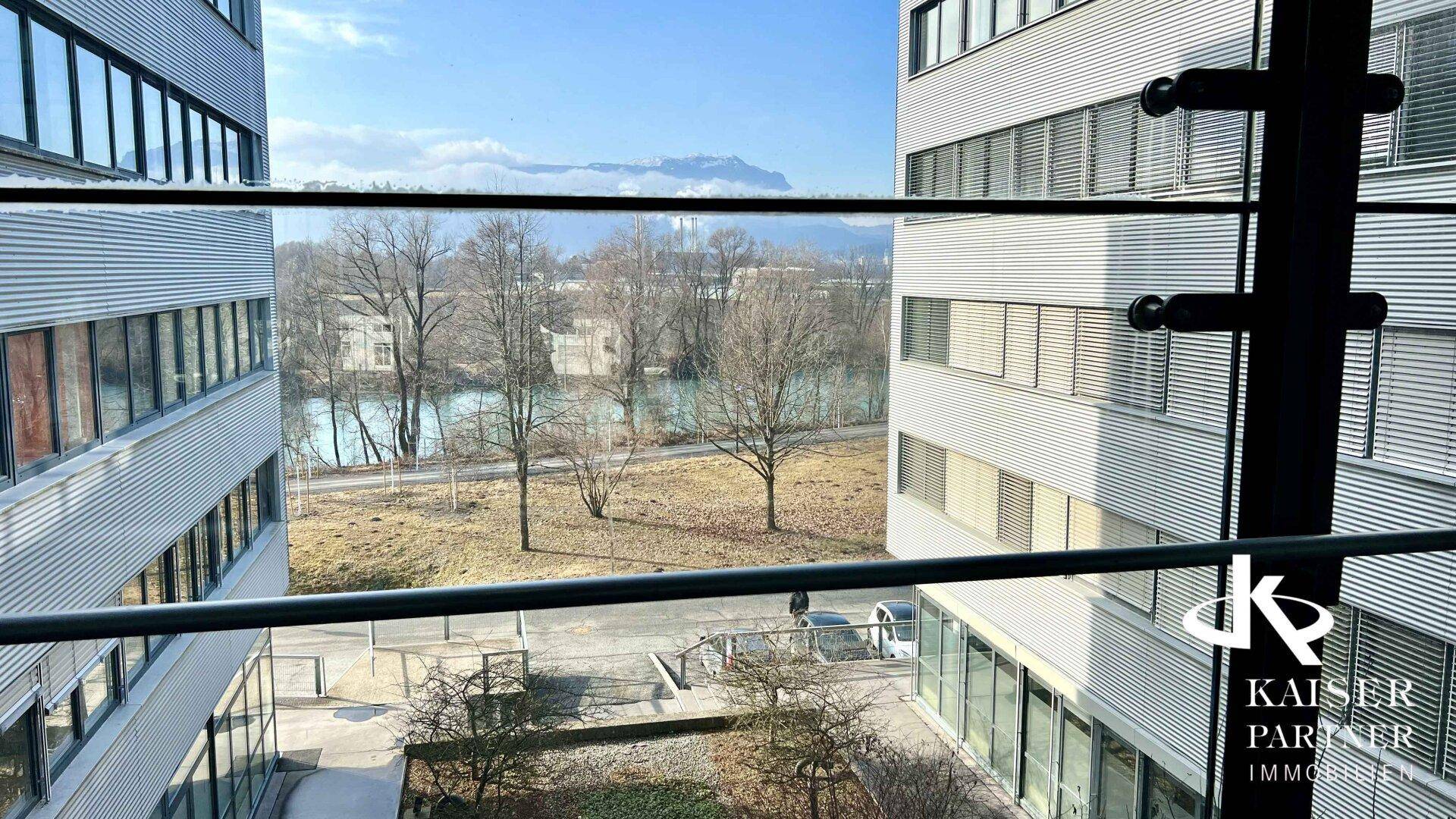 Panoramablick aus dem Fenster auf einen Fluss oder See und die umliegende Berglandschaft.