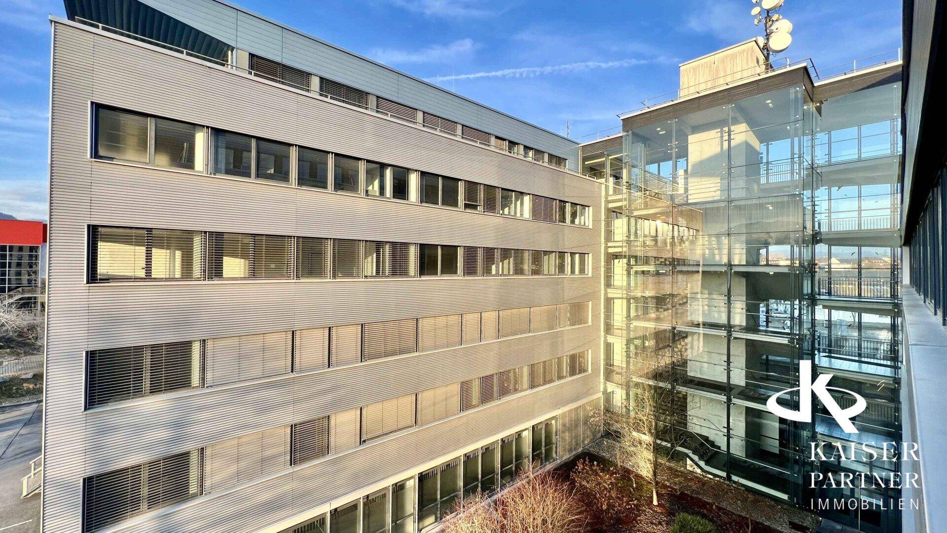 Ansicht des modernen Bürokomplexes mit Glasfassade und Innenhofbereich von oben gesehen.