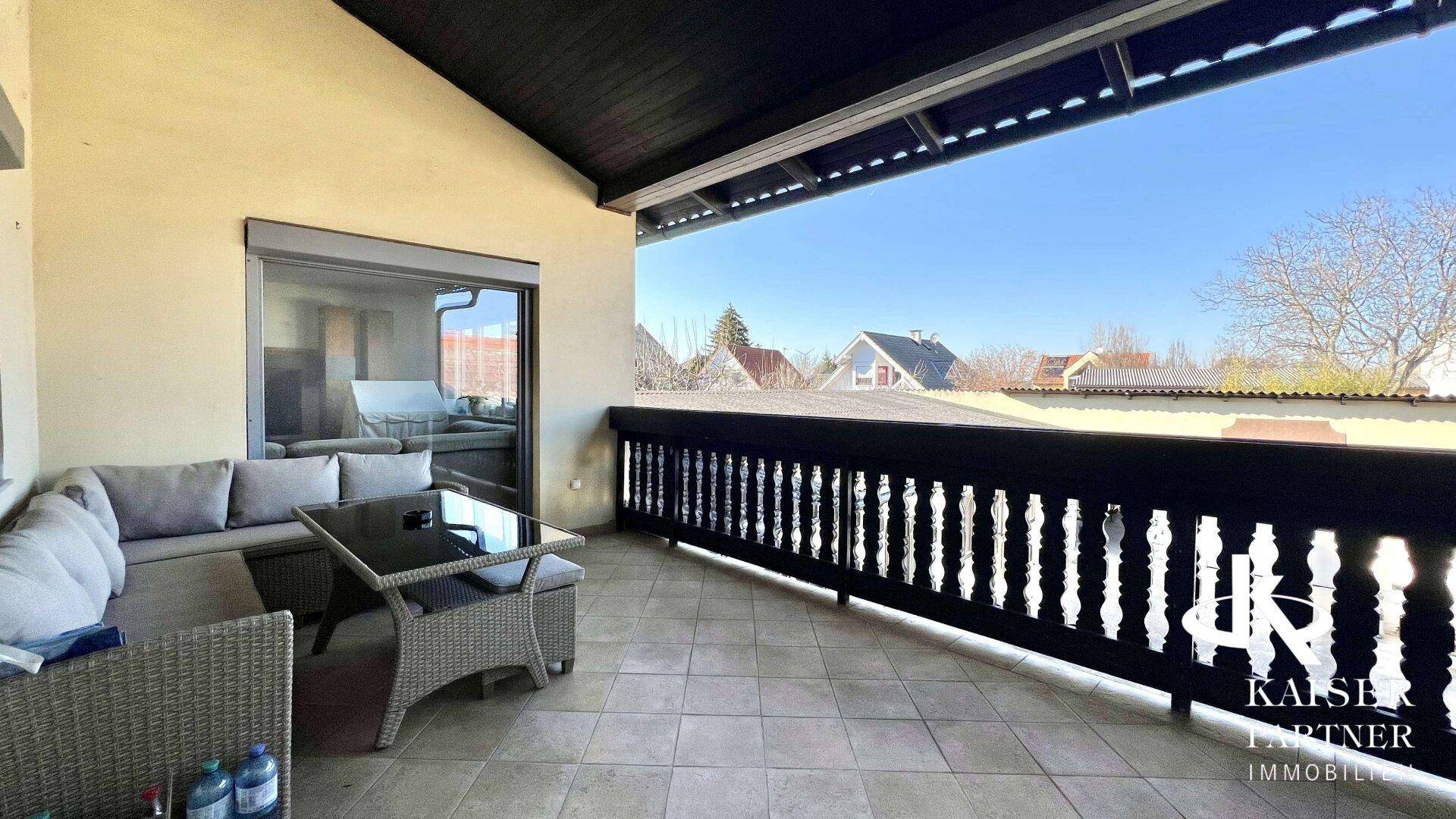 Geräumiger Balkon mit Sitzgelegenheiten und Blick auf die umliegende Nachbarschaft.