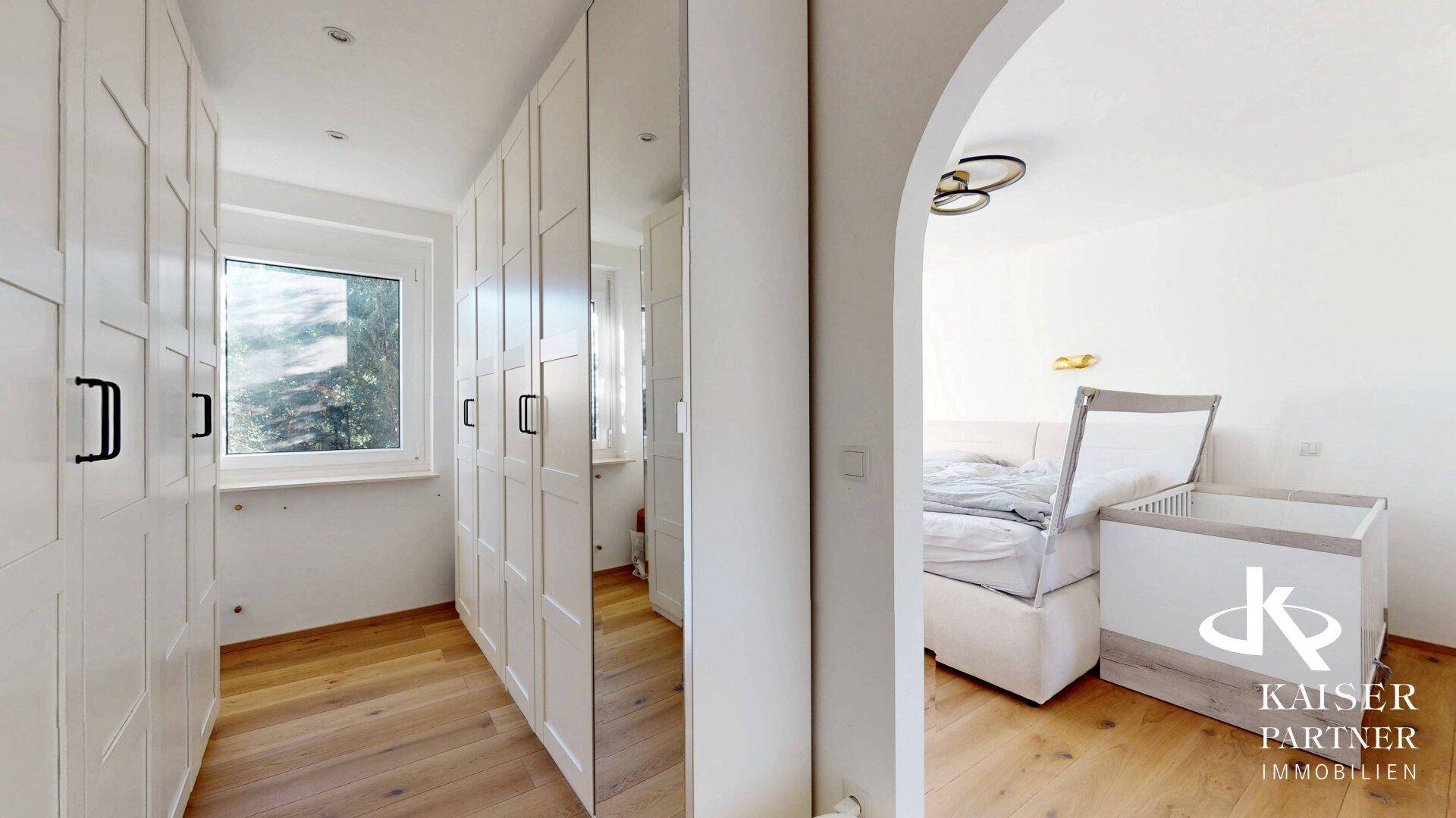 Schlafzimmer mit integriertem Kleiderschrankbereich und hellem Holzboden.